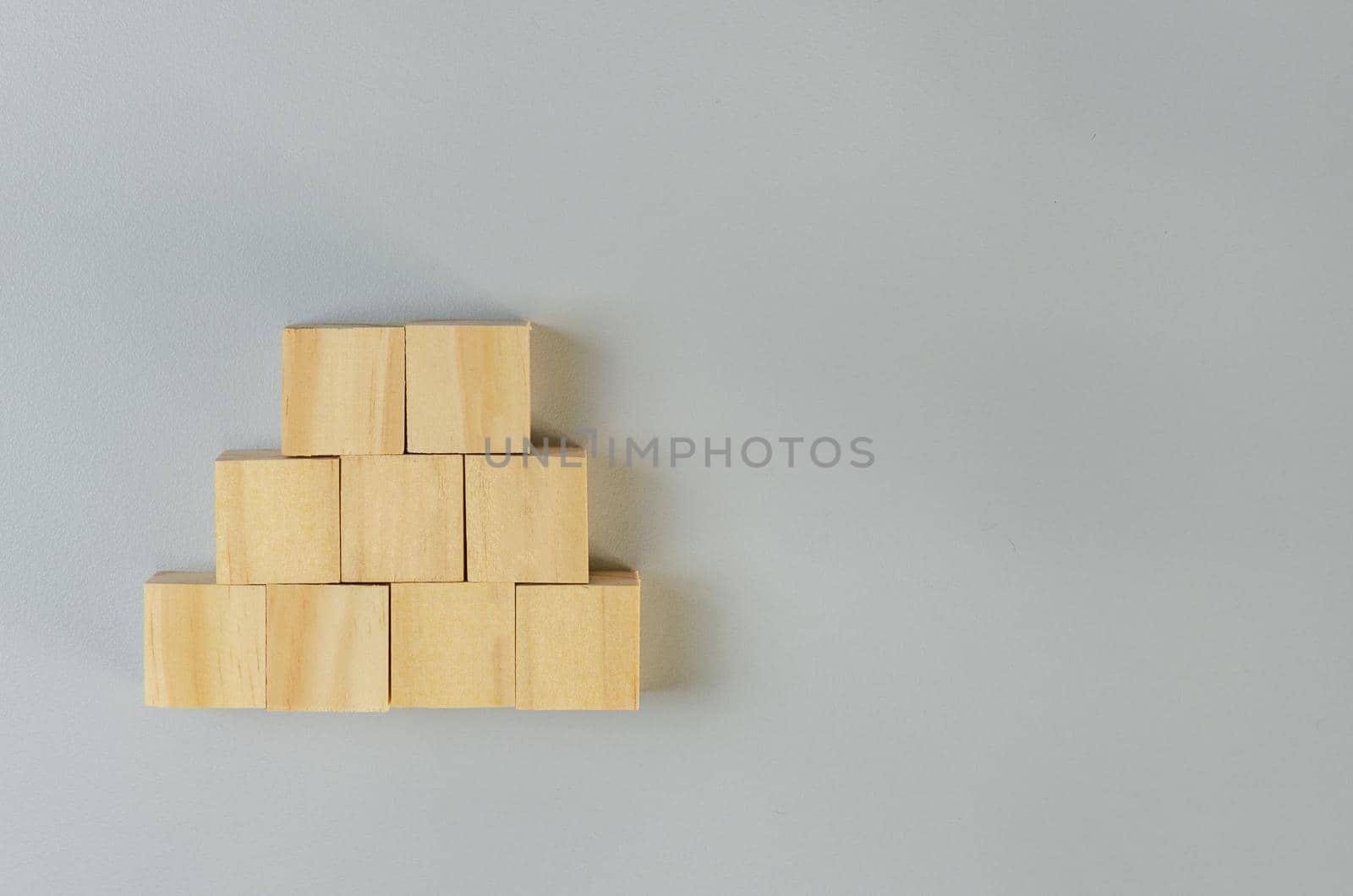 Blank wooden cubes for icons or symbols on gray background.