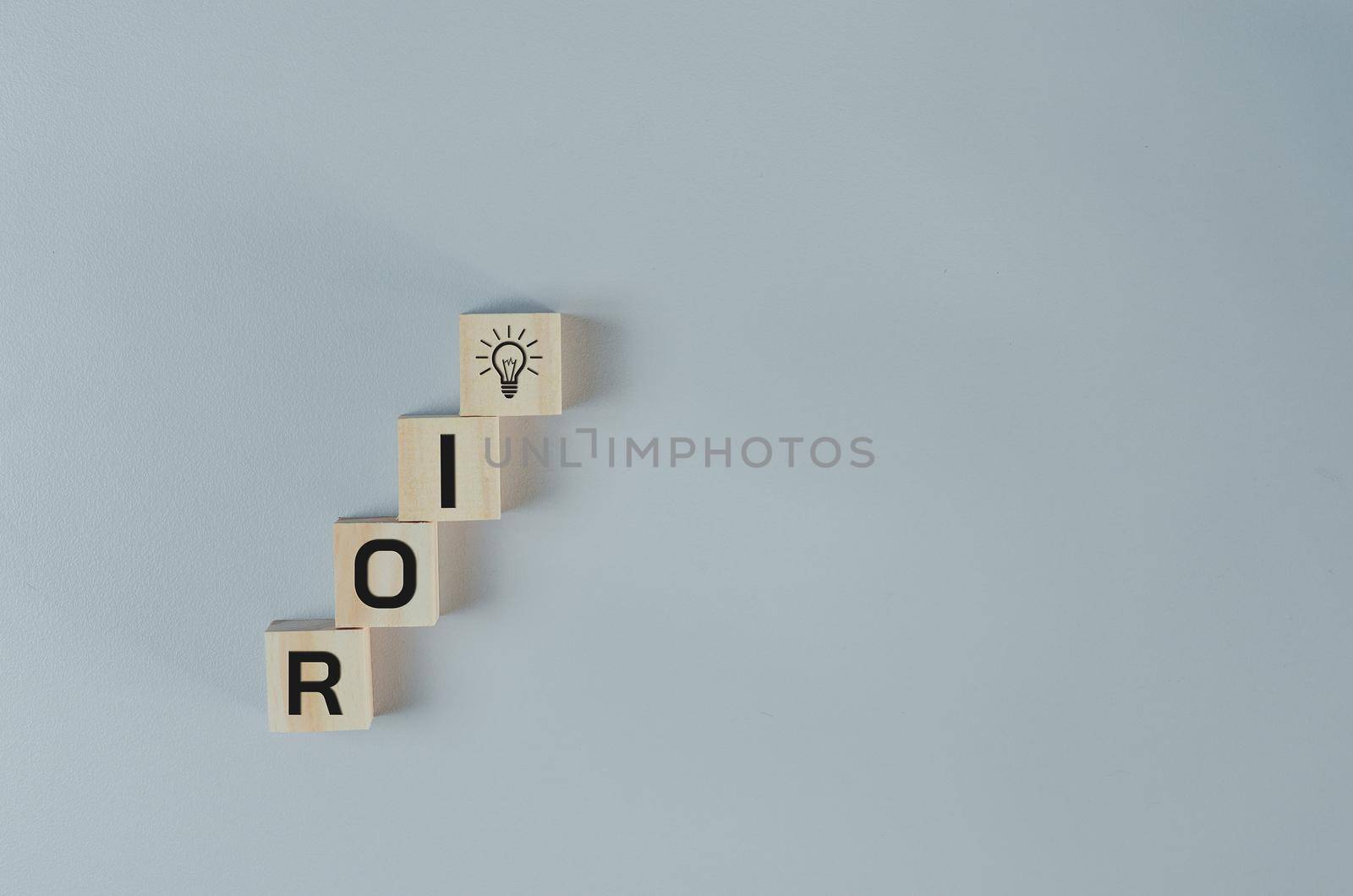 Wooden cubes with ROI Return on Investment symbol on background and copy space.Business concepts.
