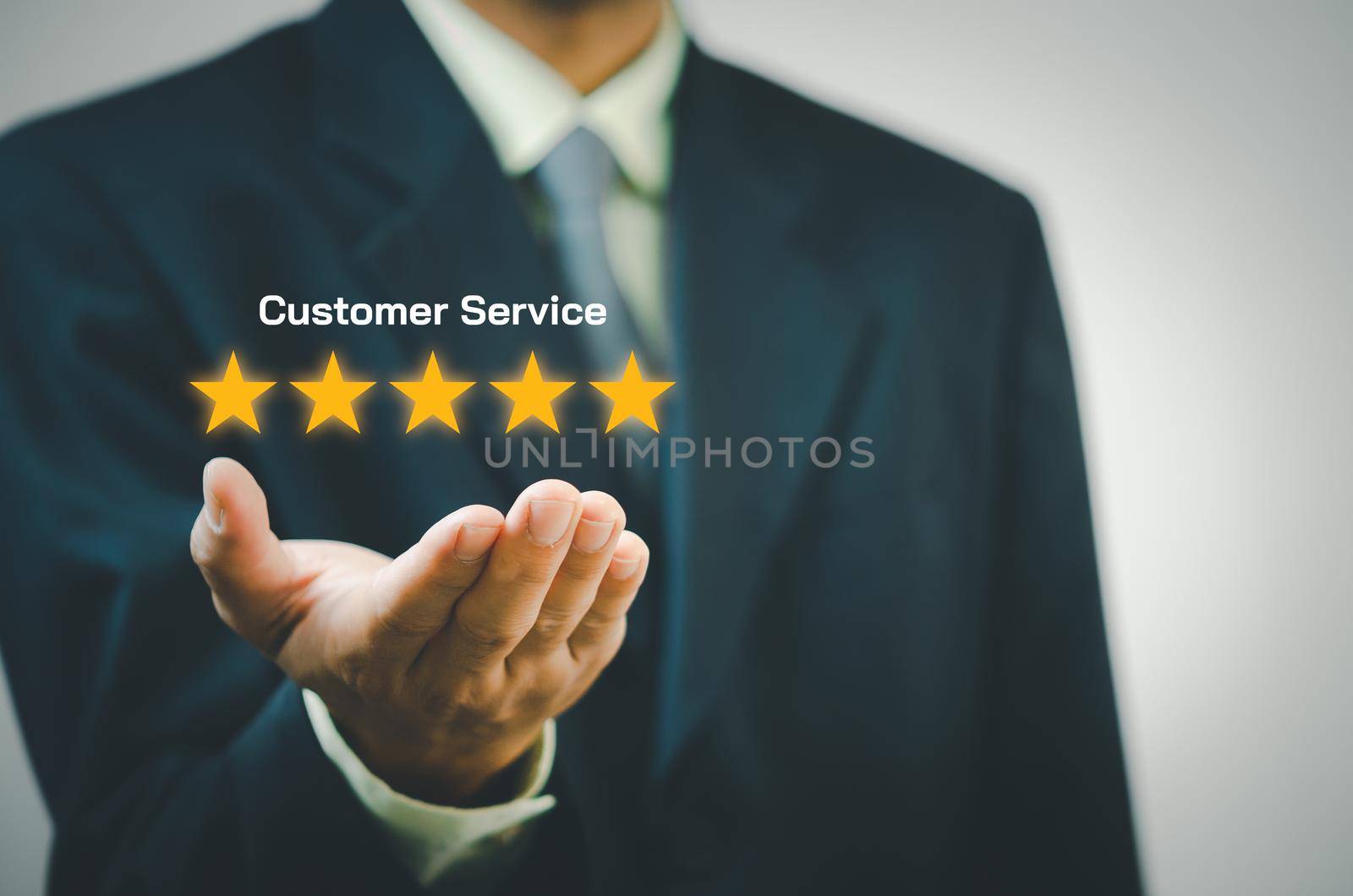 Businessman holding 5 stars on hands.Customer satisfaction and marketing survey rating concept