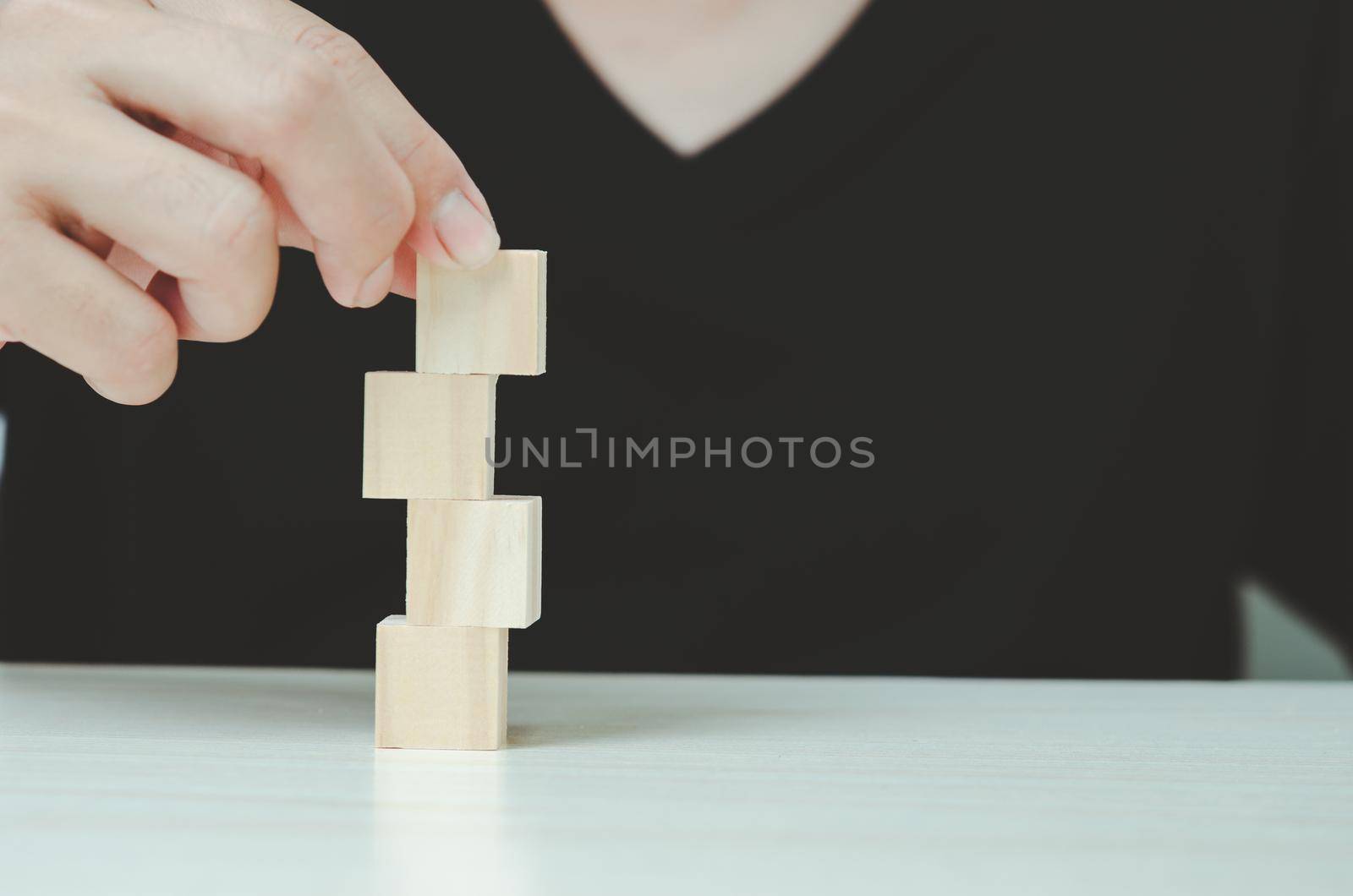 Hand putting and stacking blank wooden cubes  for icons or symbols.