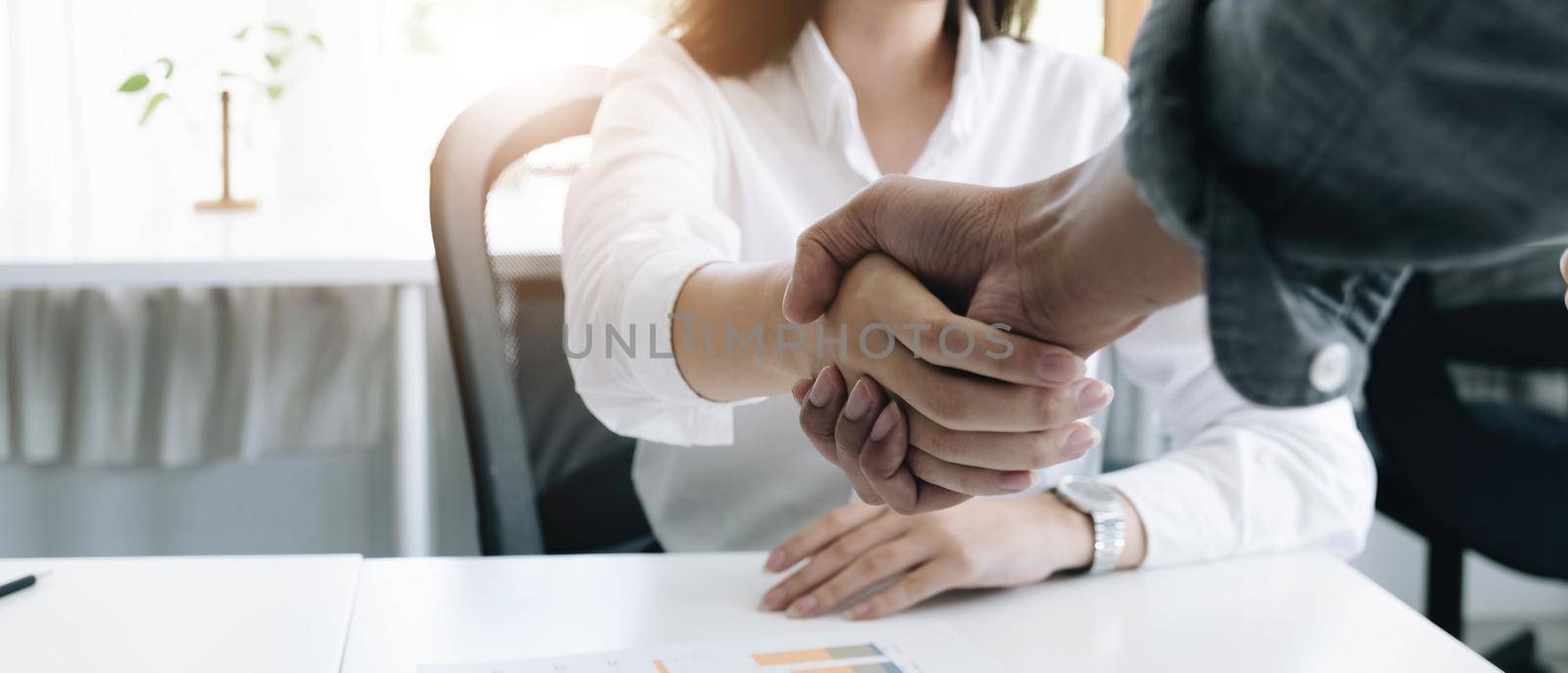 A close-up picture of a business shaking hands on a business cooperation agreement in the office. Concept of Cooperation business and success by wichayada