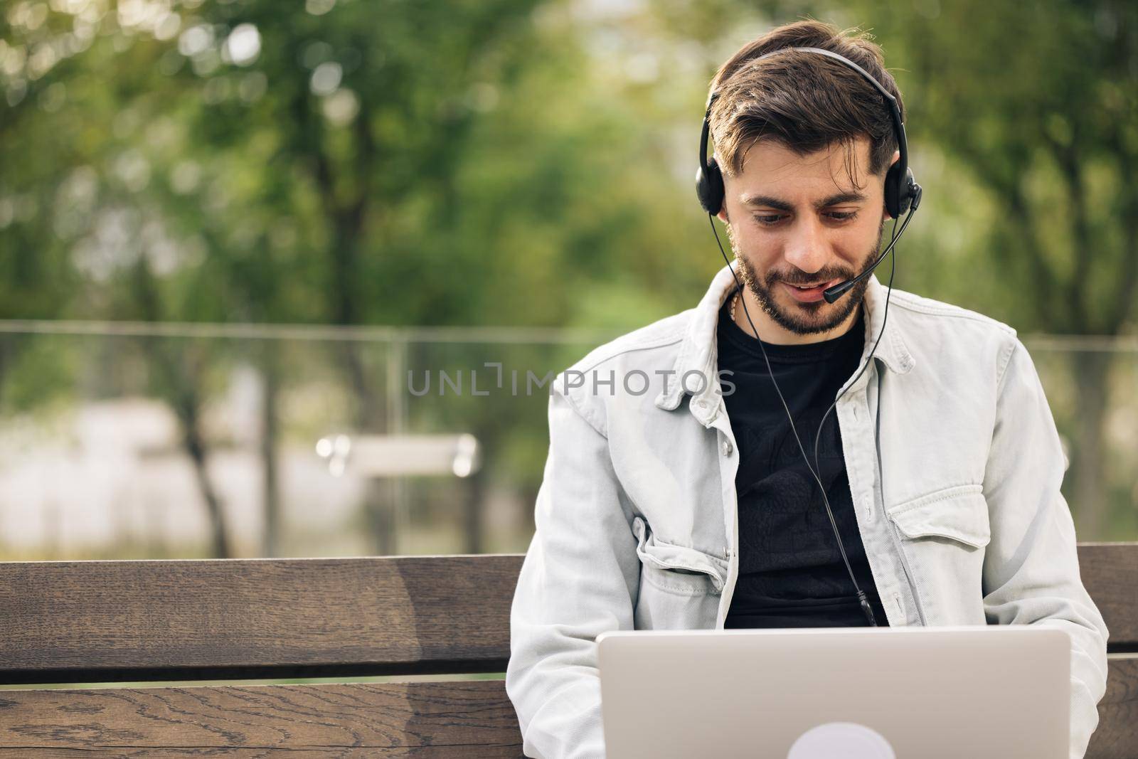 Caucasian business man wearing headphones communicating by video call. Ethnic businessman speaking looking at laptop computer, online conference distance office chat, virtual training concept by uflypro