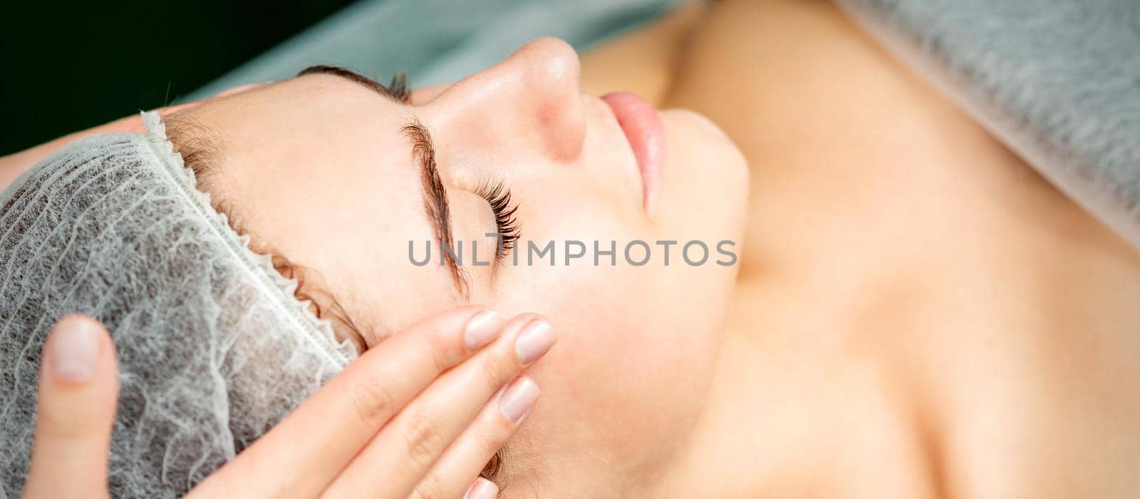 Young woman getting facial massage by okskukuruza