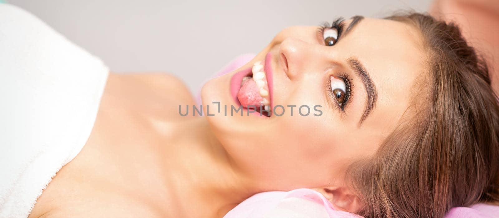 Young woman sticking out tongue by okskukuruza