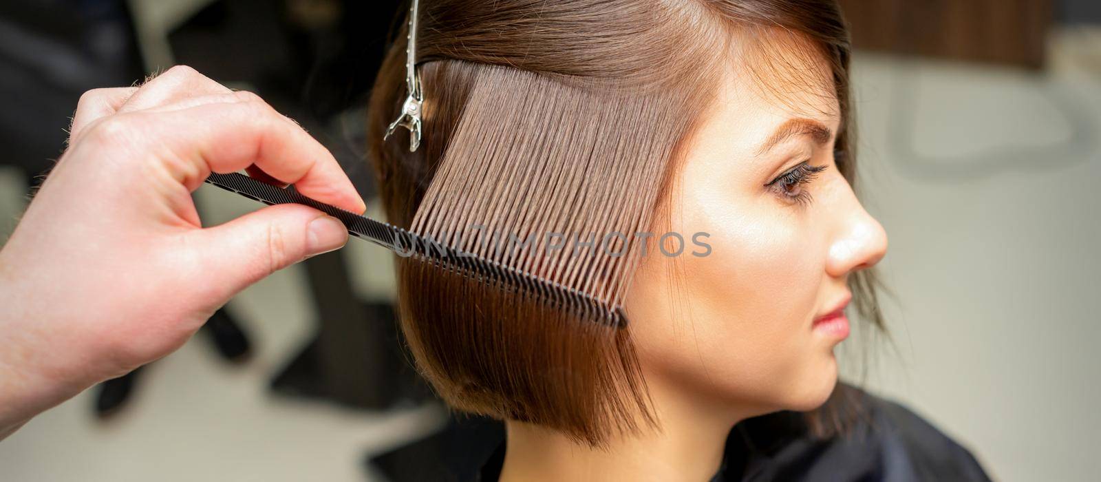 Hairdresser brushing straight female hair by okskukuruza