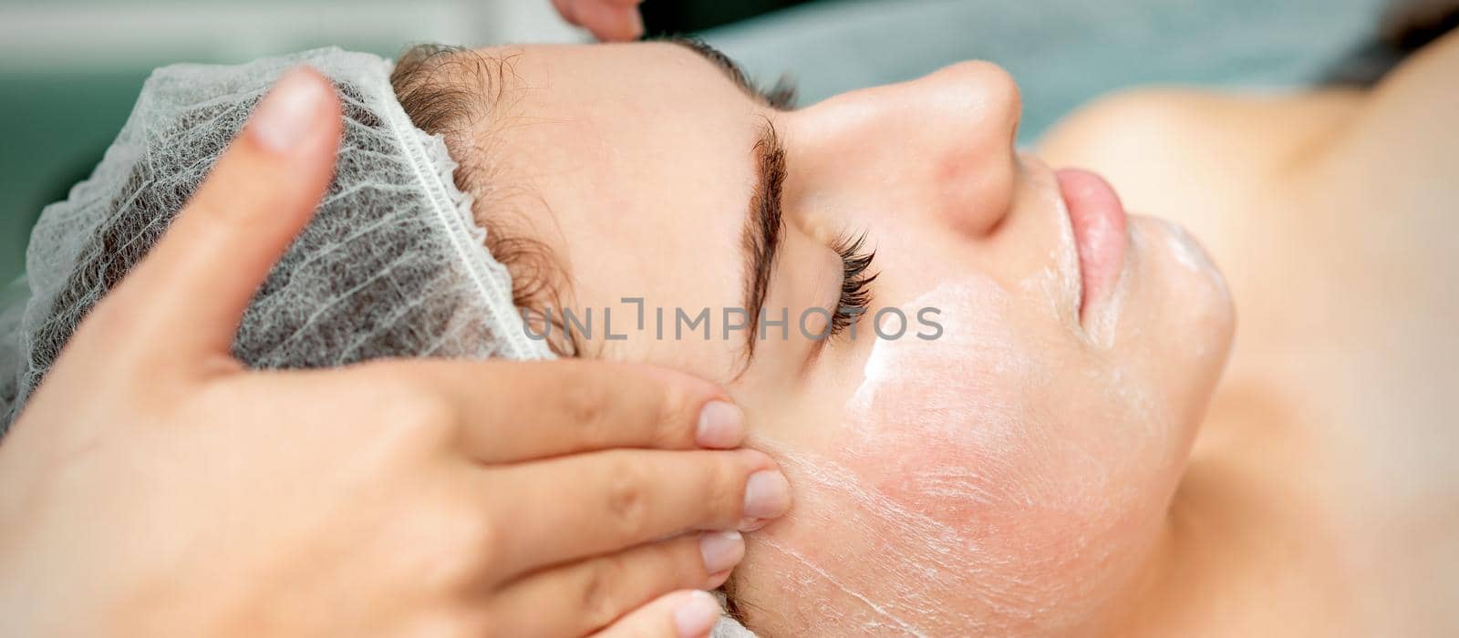 Young woman getting facial massage by okskukuruza