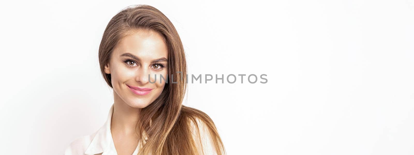 Pretty smiling beautiful woman with dark hair, dressed in a white shirt, looking at camera isolated against the white background with copy space