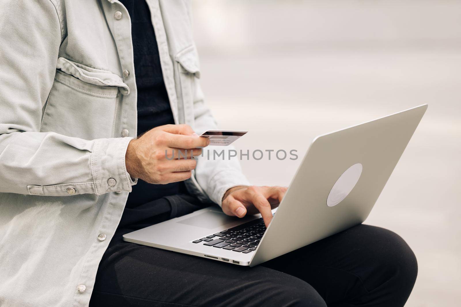 Close up view male hands of cardholder holding credit card making e bank online payment. Man consumer paying for purchase in web store using laptop technology. Ecommerce website payments concept.