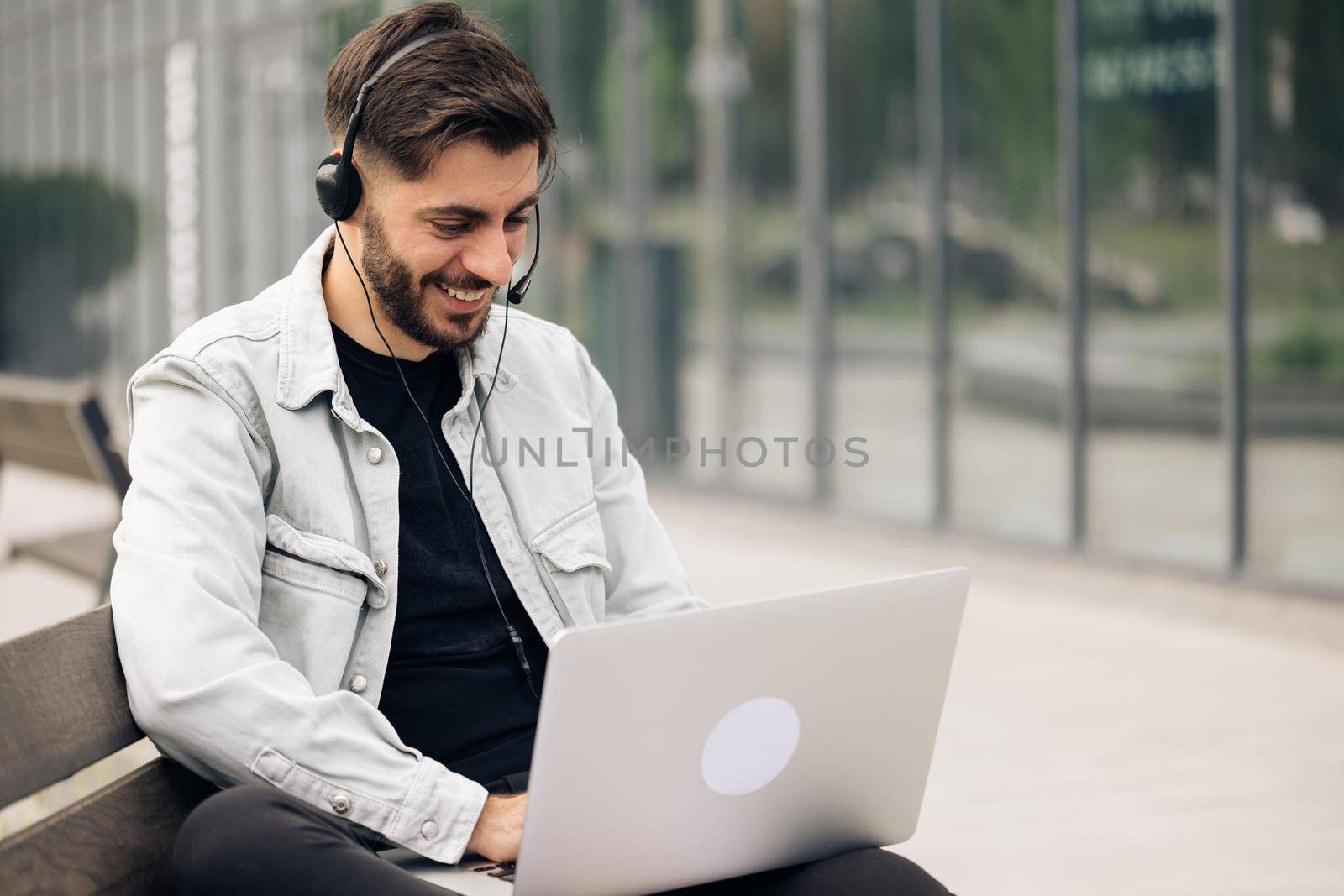 Ethnic businessman speaking looking at laptop computer, online conference distance office chat, virtual training concept. Caucasian business man wearing headphones communicating by video call.