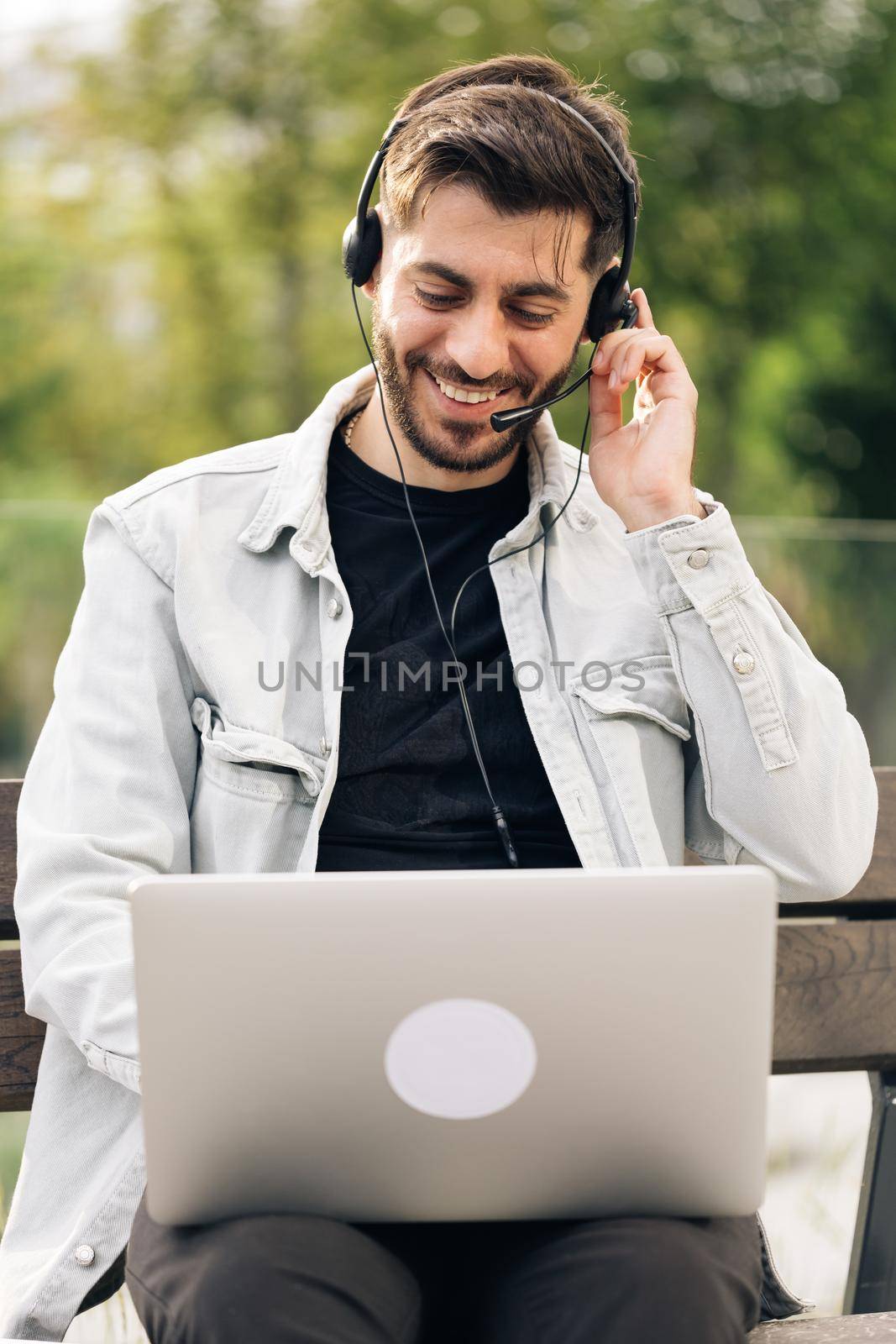 Portrait armenian business man assistant helpline operator online store service manager wears headphones speaks into microphone answers call client partner leads negotiations advises online sales. by uflypro