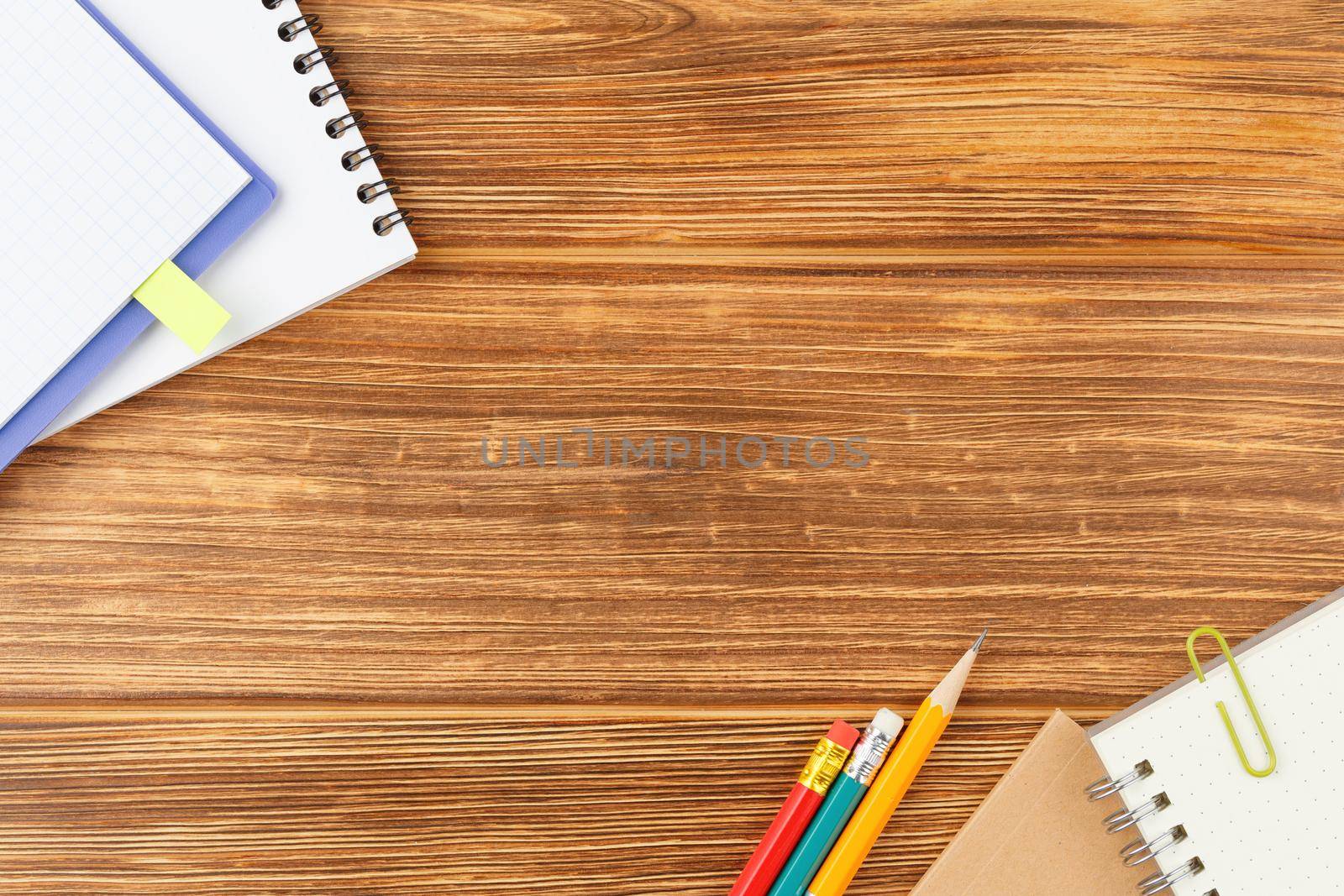 School notebook with pencil and alarm clock on a wooden background. Flat lay. Back to school concept. Study desk. Flat lay.