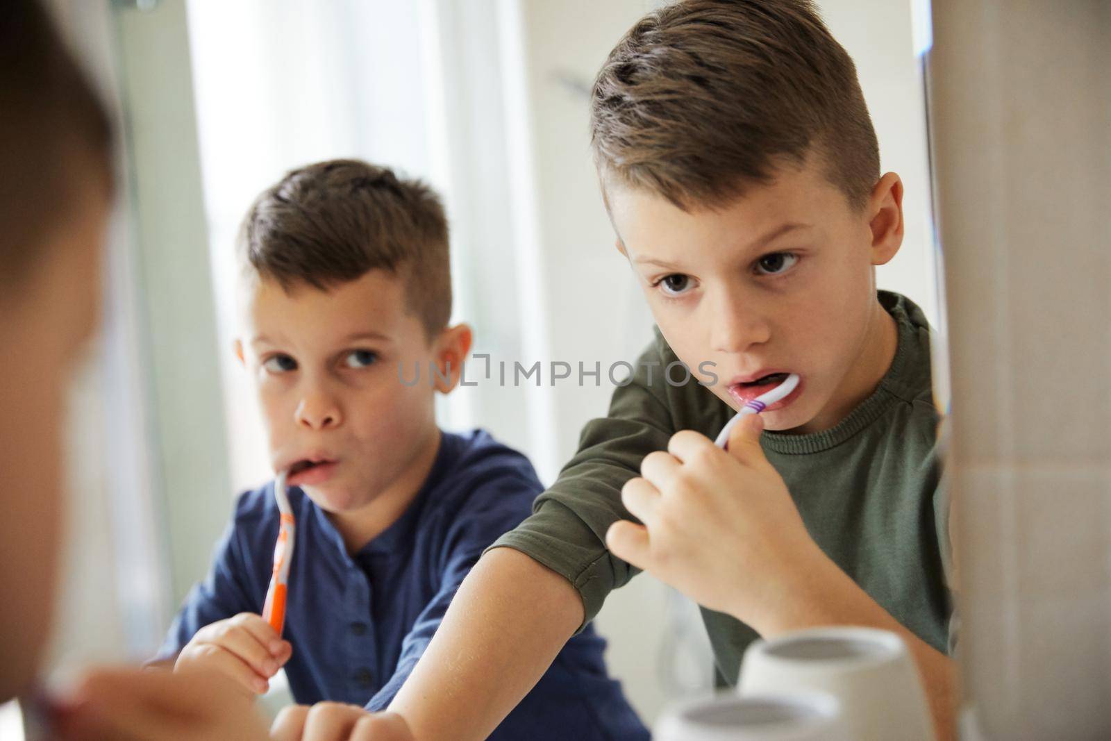 Little cute brothers washing teeth in the bathroom