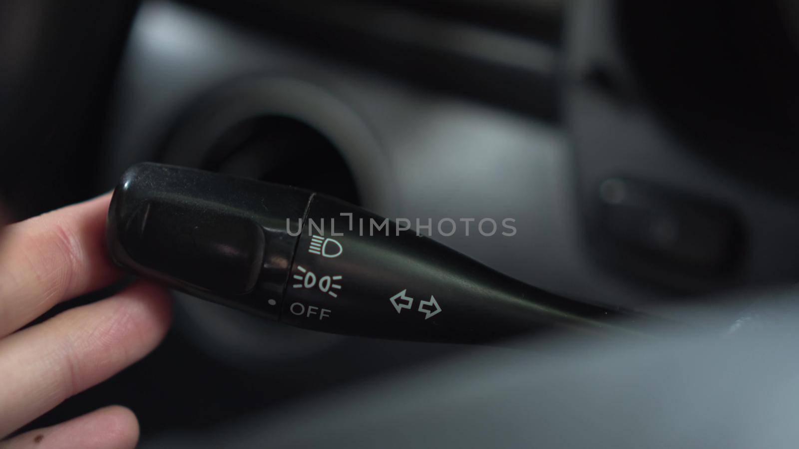 A man turns on the turn signal to the left on the lever in the car. Automotive panel close-up. 4k