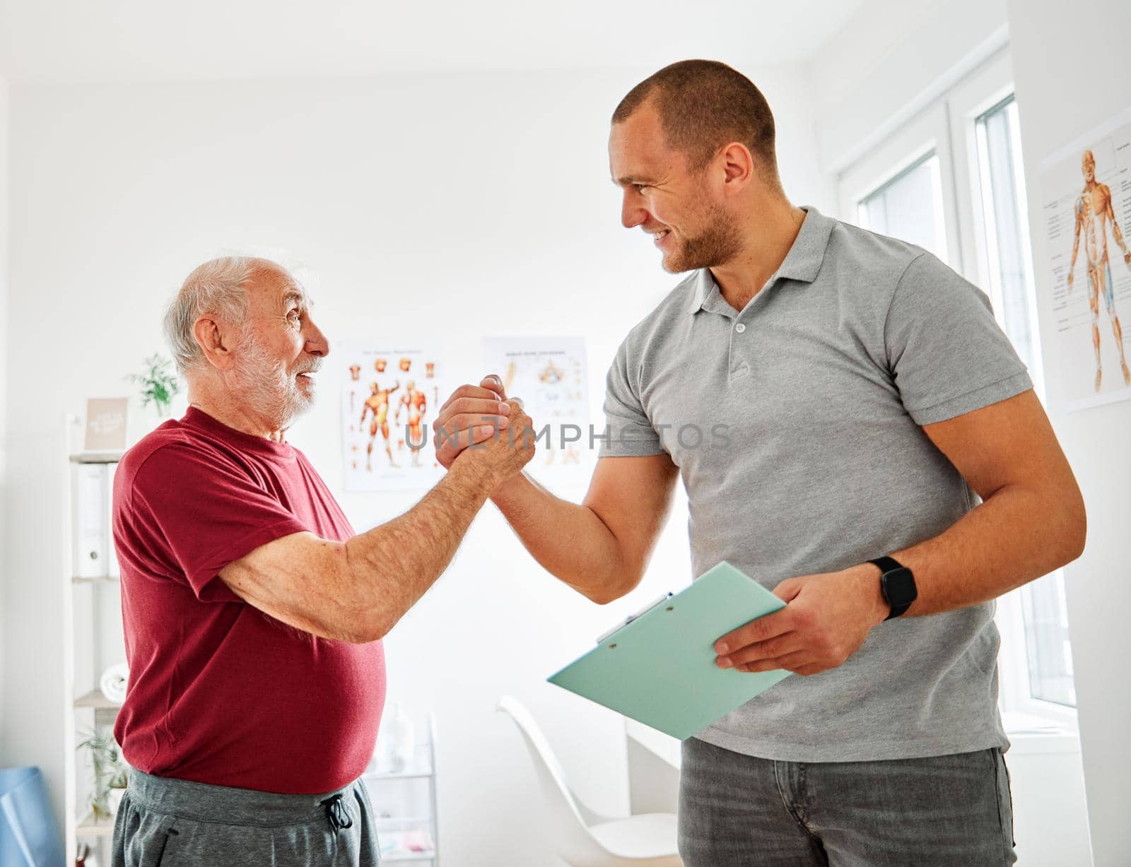 Doctor or therapist exercise with senior man at clinic or nursing home