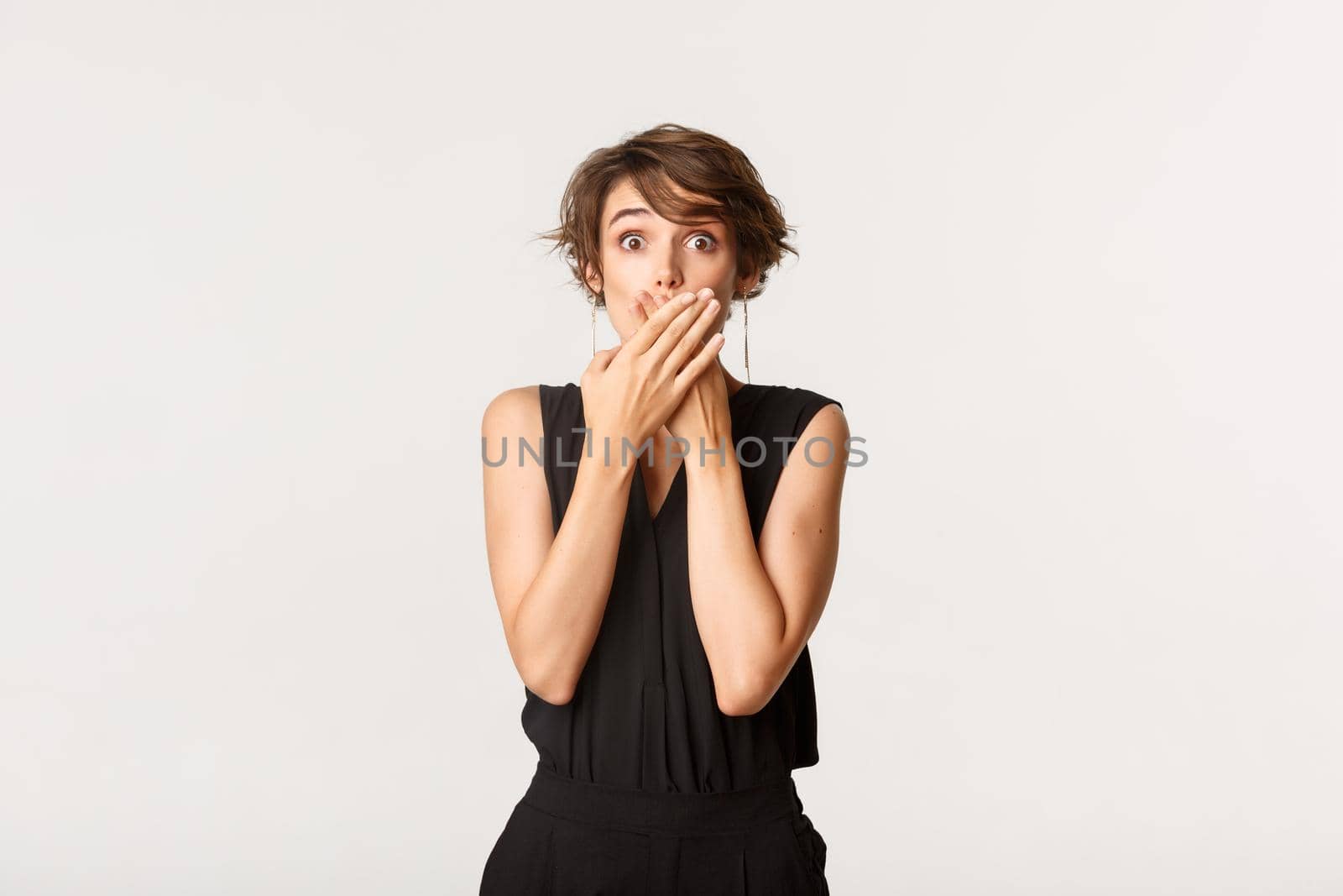 Shocked young woman found out secret, gasping and shut mouth with hands amazed, standing white background by Benzoix