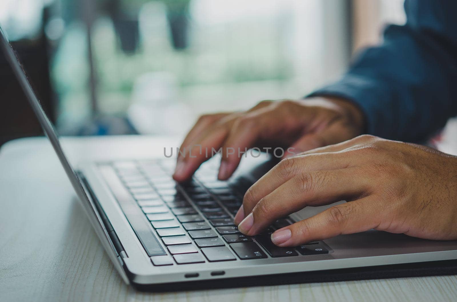 man using computer laptop searching internet, sending sms, using text messenger or online banking.