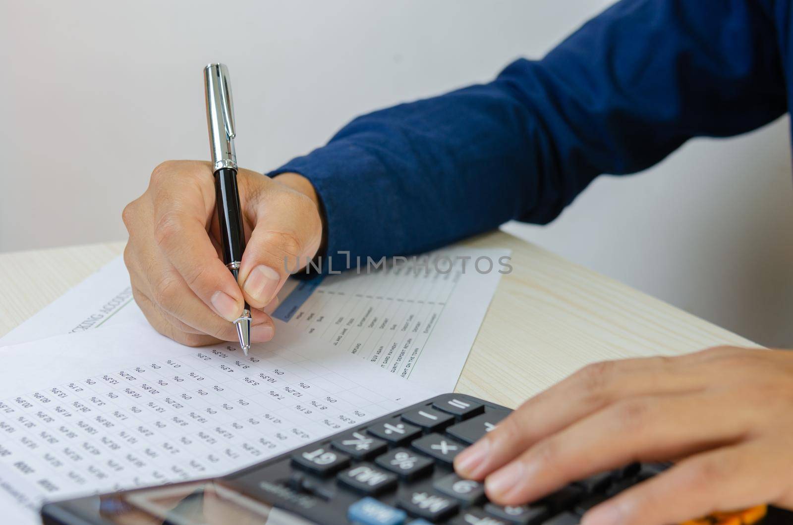 Business Man using calculator at a desk. Business finance, tax, economy
loan and investment concepts.