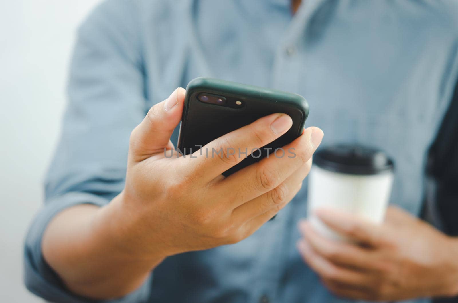 hand man holding smartphone and coffee paper cup.