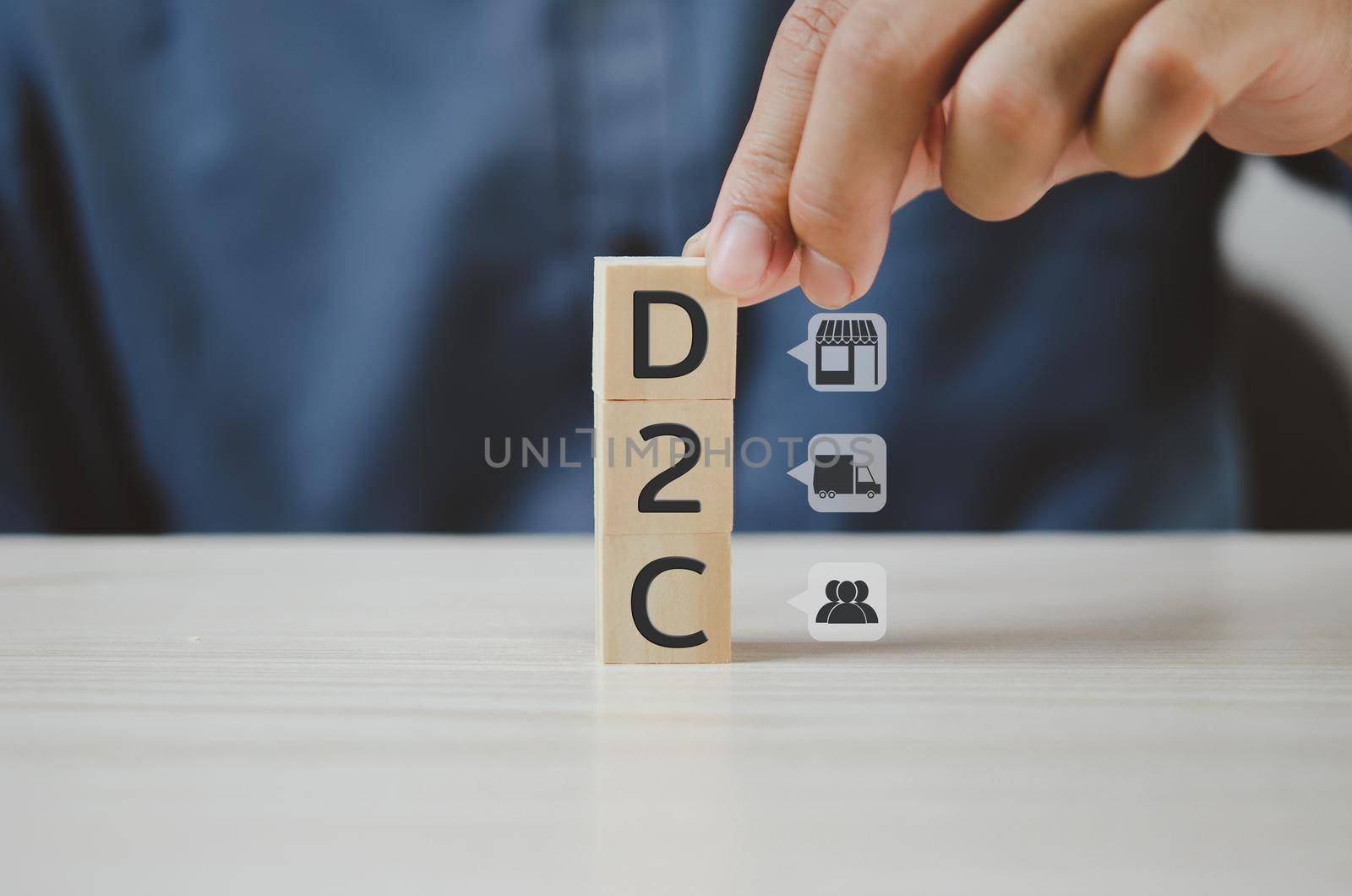 Hand put wooden cubes with Direct to Consumer D2C and icon on table and copy space.Business concepts. by aoo3771