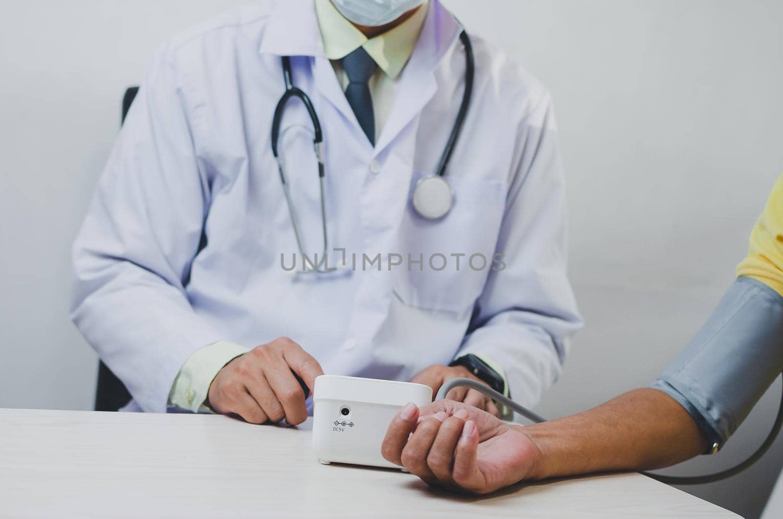 doctor measures the blood pressure of an elderly male patient.