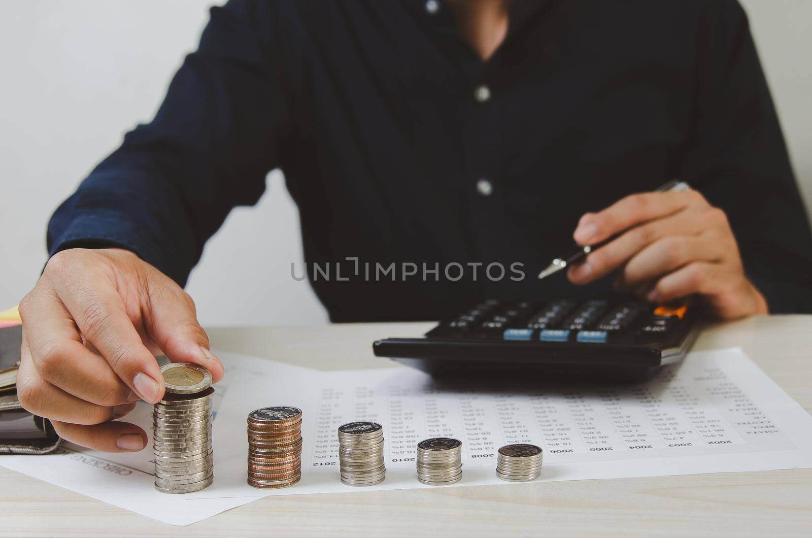 Male hands holding coins and paper documents calculator.Business economic finance tax and investment concepts.