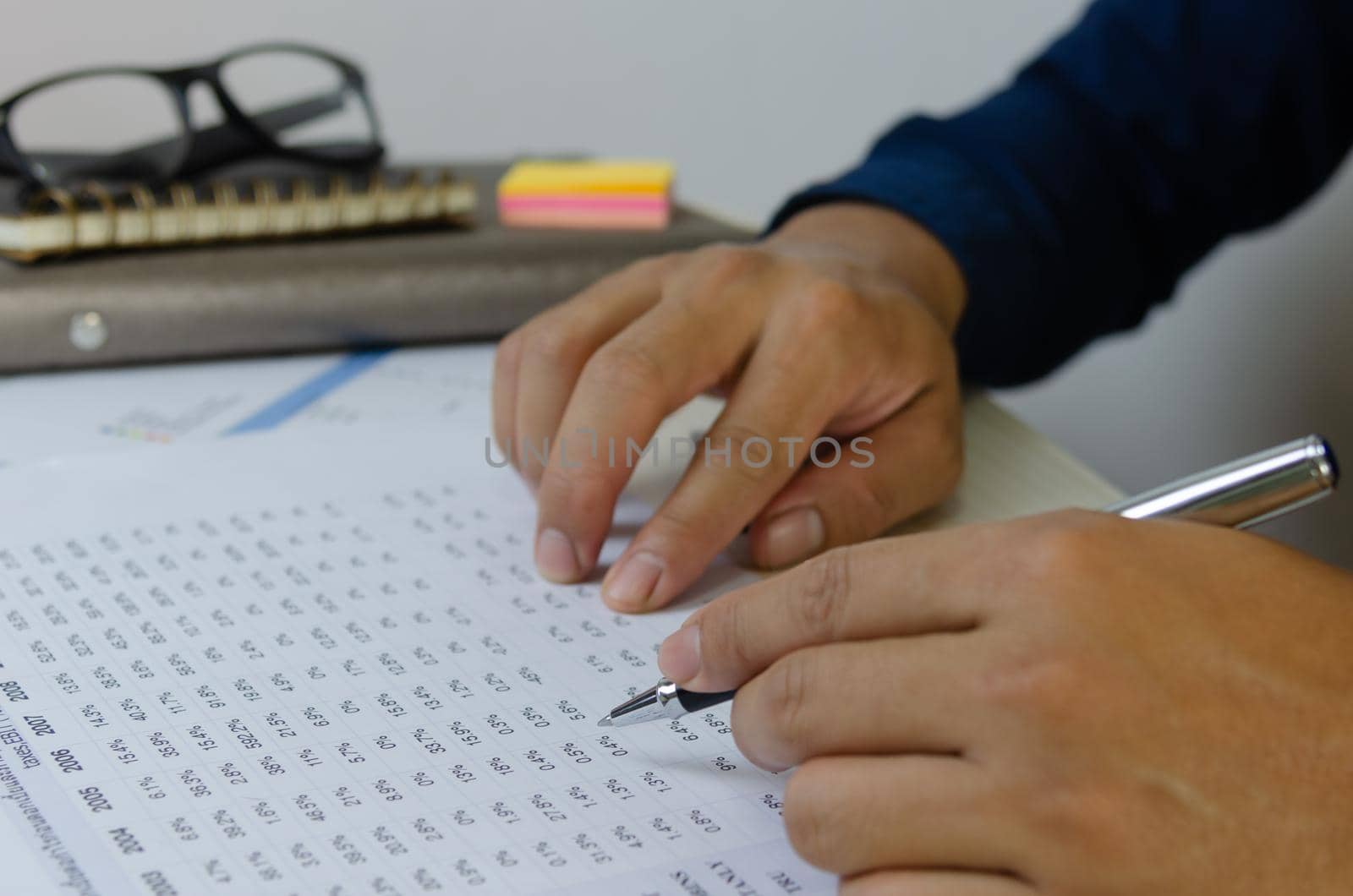 Man hand holding a pen and document paper work marketing financial plans Tax and business investment.