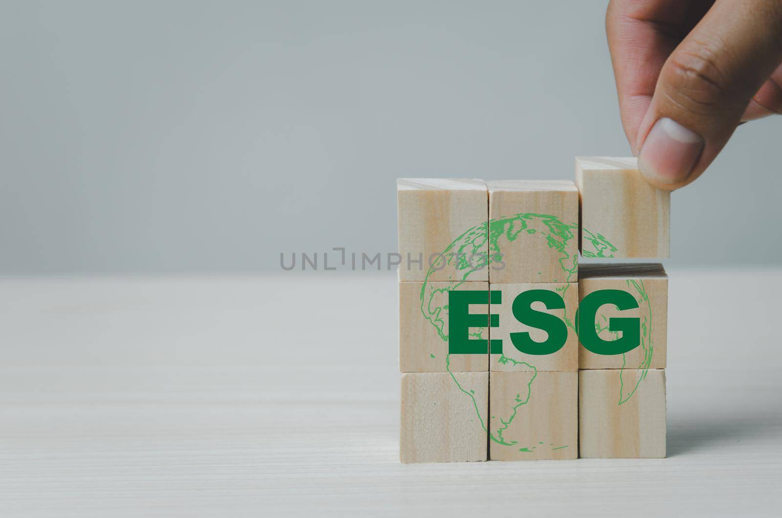 Hand put wooden cubes with ESG Environmental Social Governance symbol on table copy space.Business concepts. by aoo3771