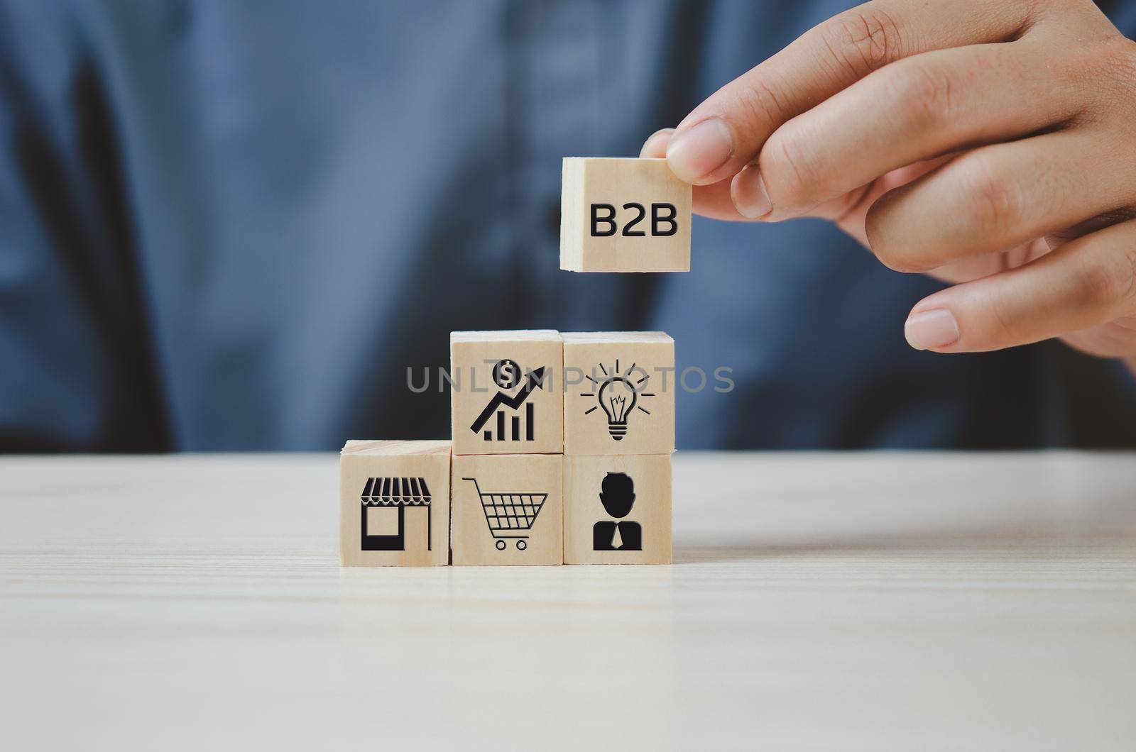Hand put wooden cubes with  B2B Business to Business icons and symbols on table and copy space.Business concepts. by aoo3771