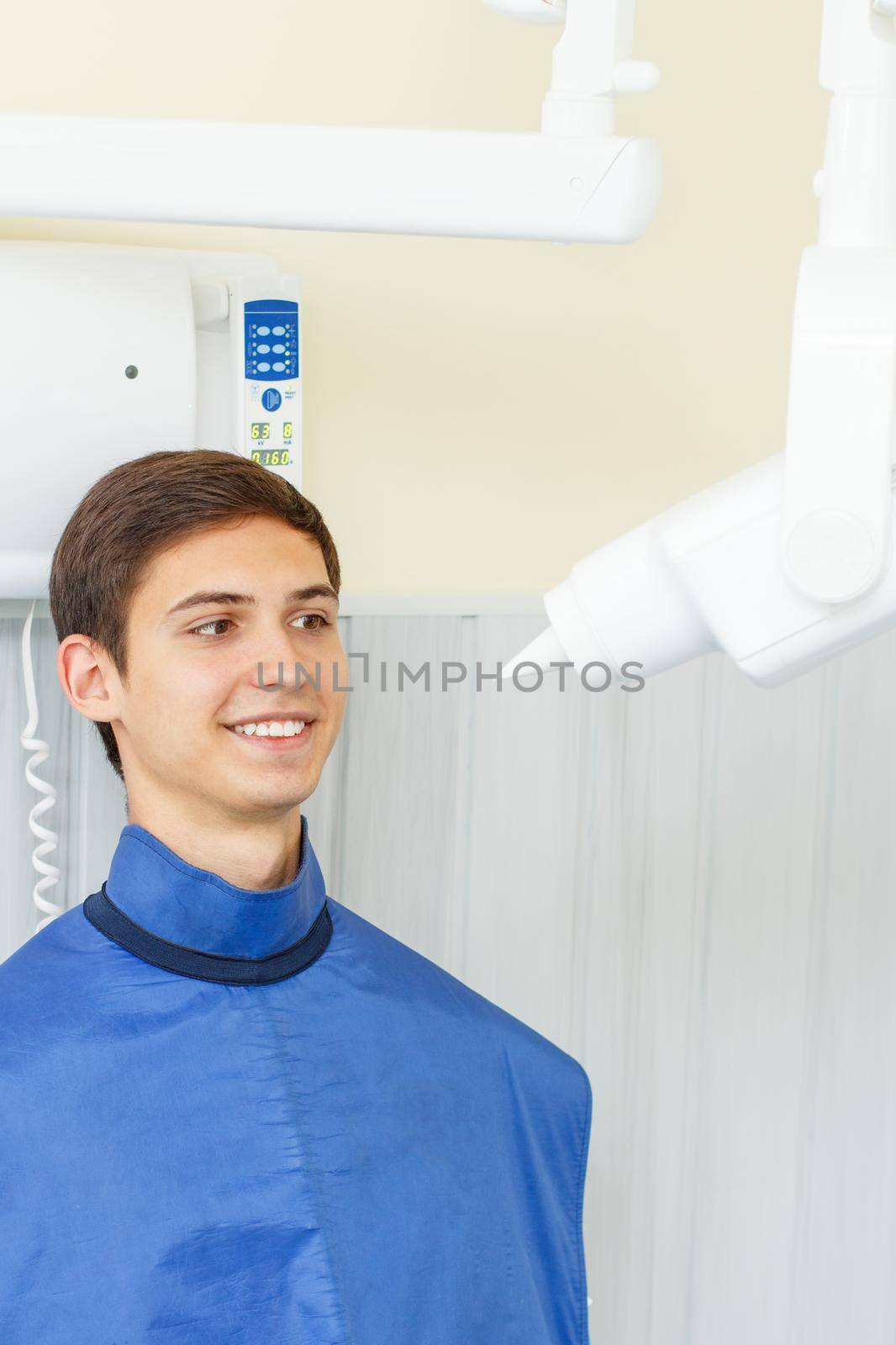 X-ray machine and handsome young man in a dental office. Dental equipment