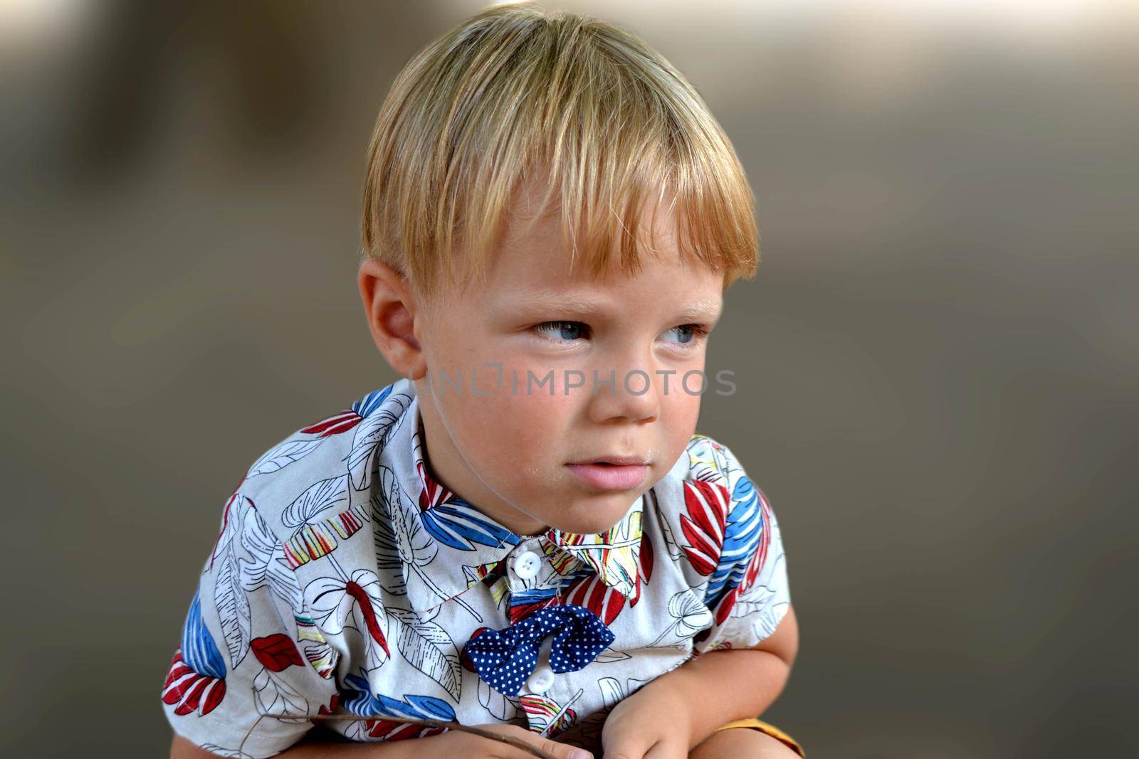 Blond boy 4 years old playing on a children playground and has fun. High quality photo