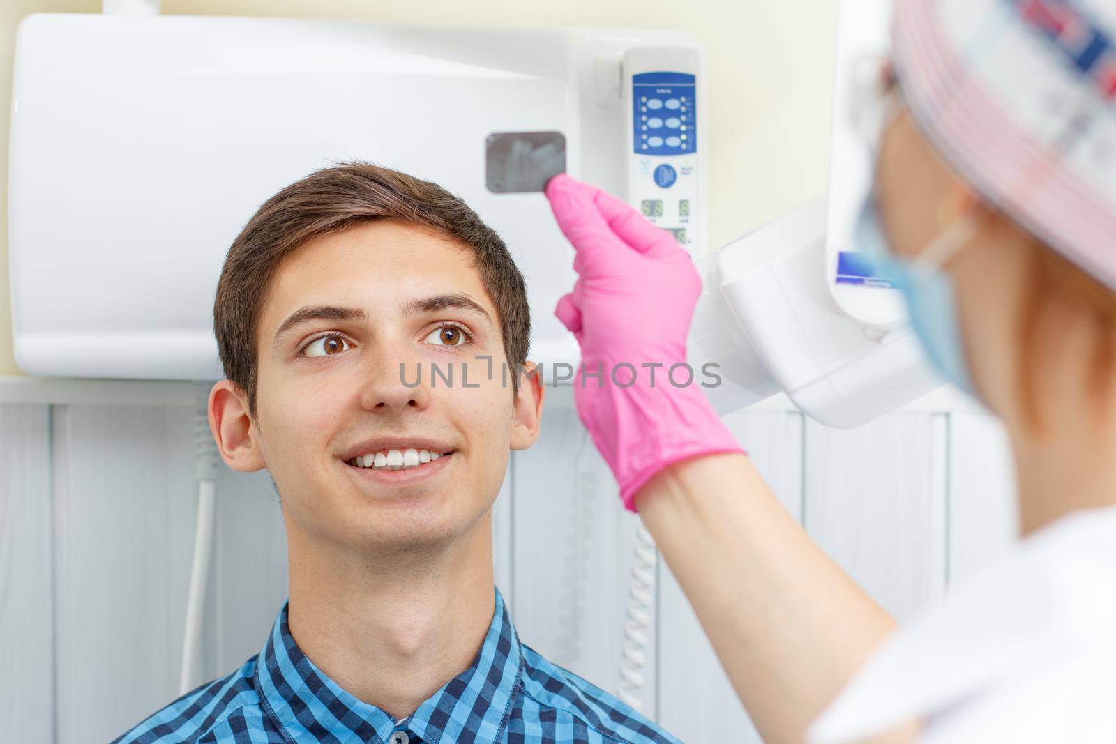 Female dentist and patient in the dental office are looking at a dental x-ray. Dentistry