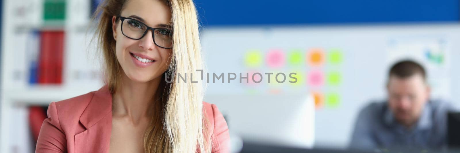 Portrait of pretty businesswoman sit in office with paperwork in presentable suit. Smiling secretary work in big corporation. Business, office life concept