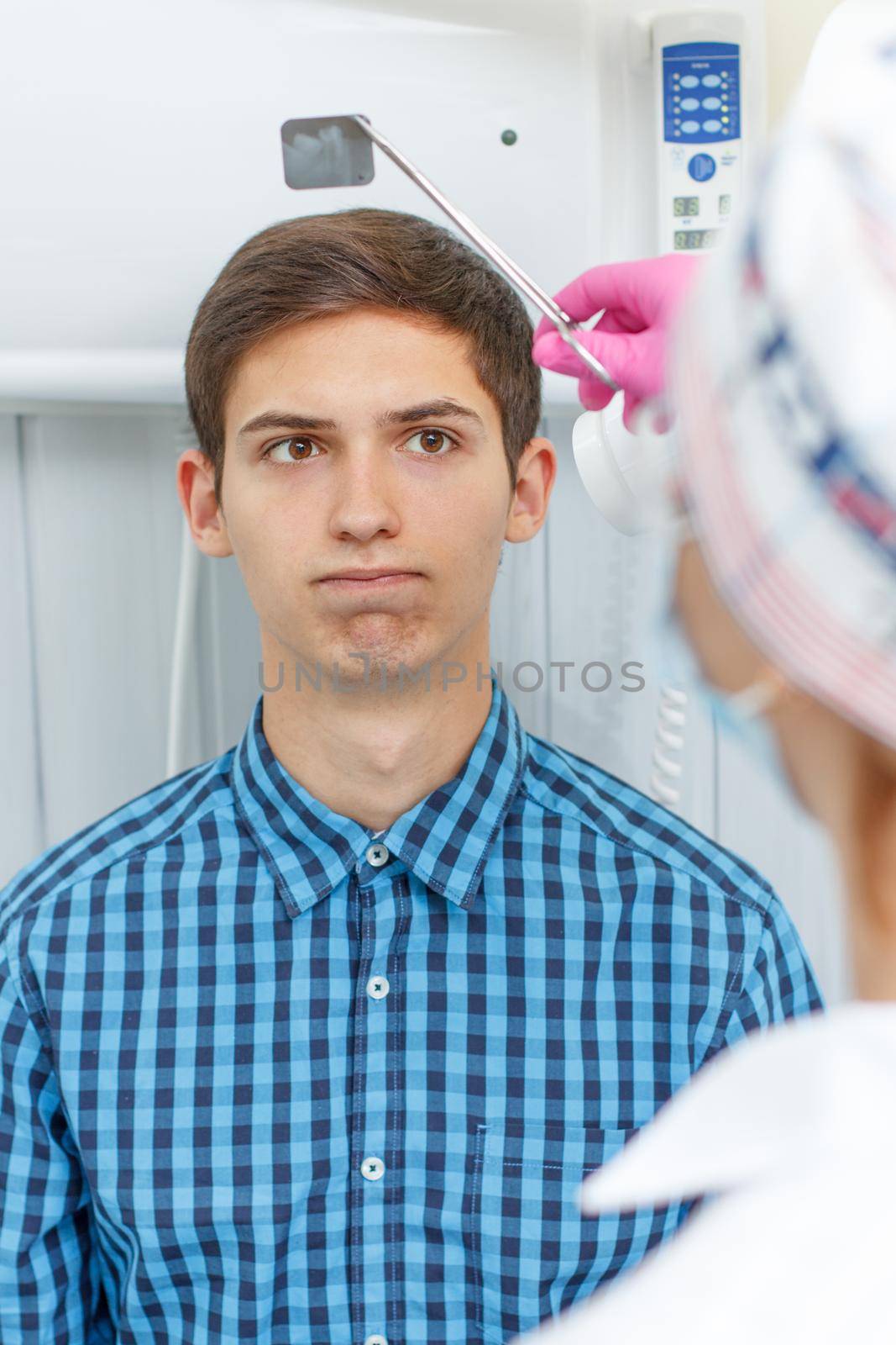 Female dentist and patient in the dental office are looking at a dental x-ray. The patient is disappointed with the results. Dentistry