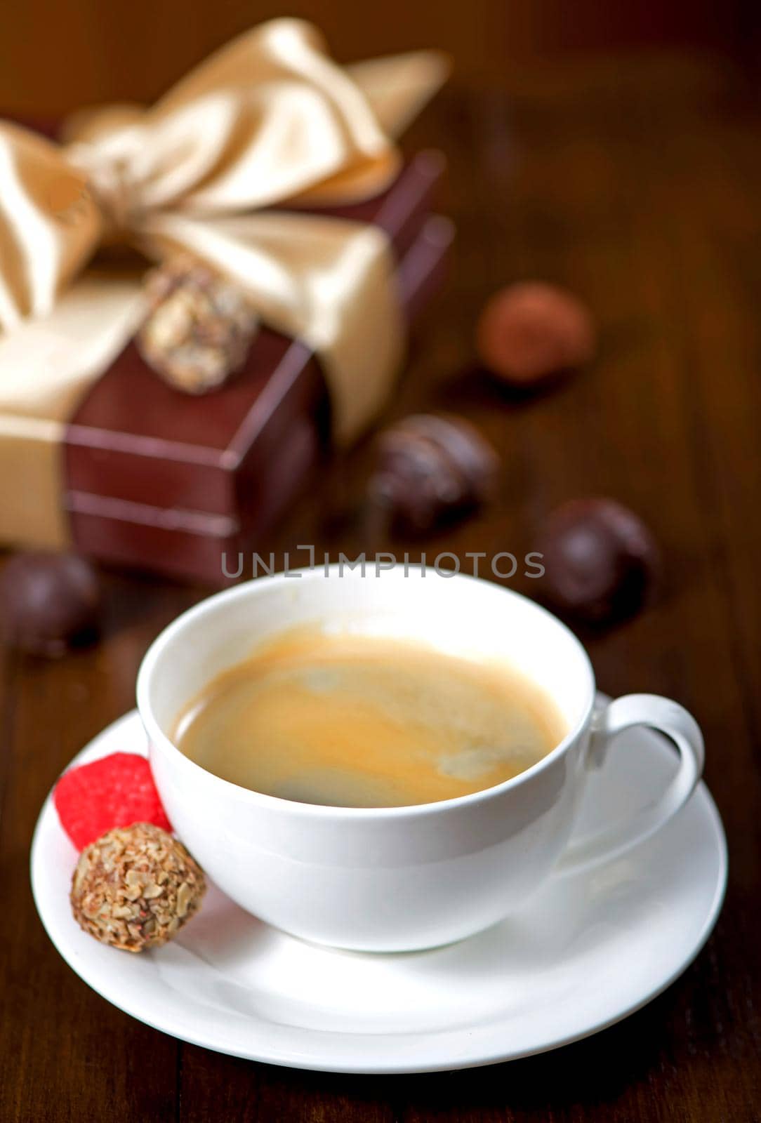 a cup of coffee and candy on vintage wooden background