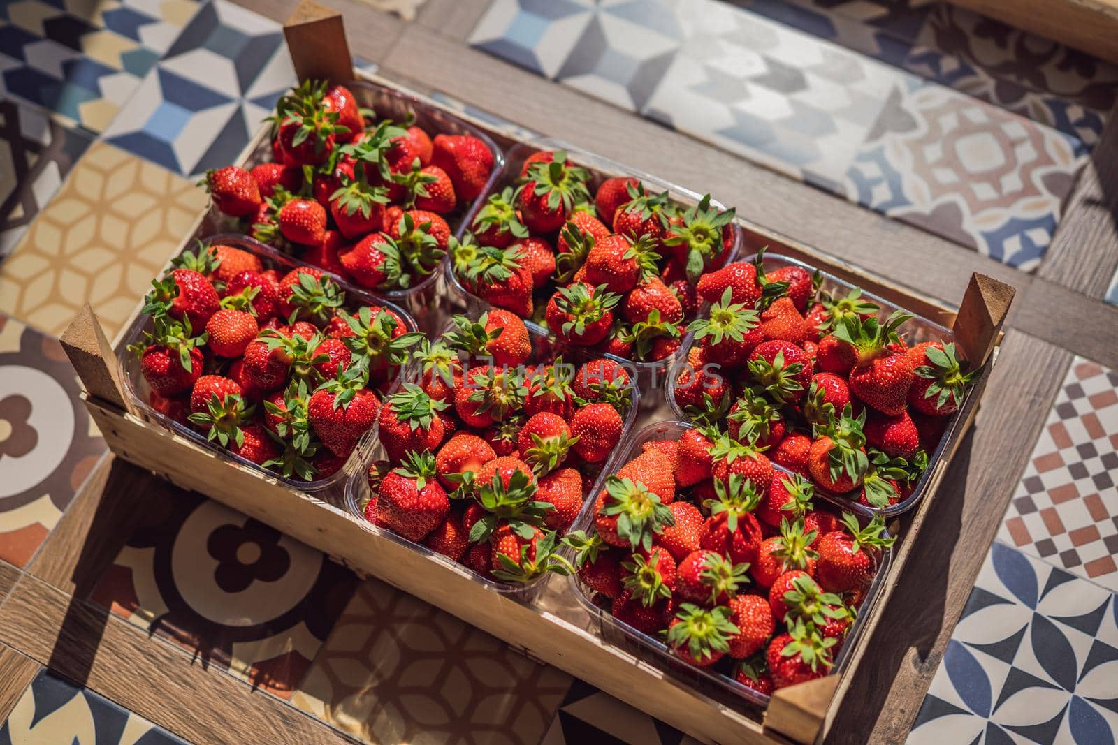 wooden box full of fresh organic strawberries on white background. top view by galitskaya