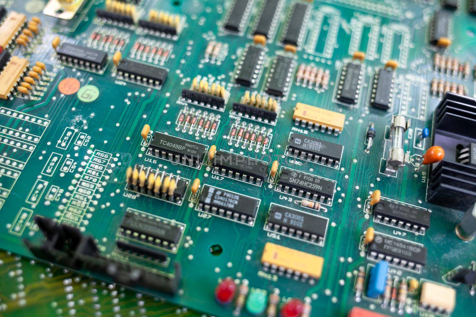 Old computer chips that are out of order. Not working microshops with transistors, chips and conductors. Blue system board with microchips and transistors