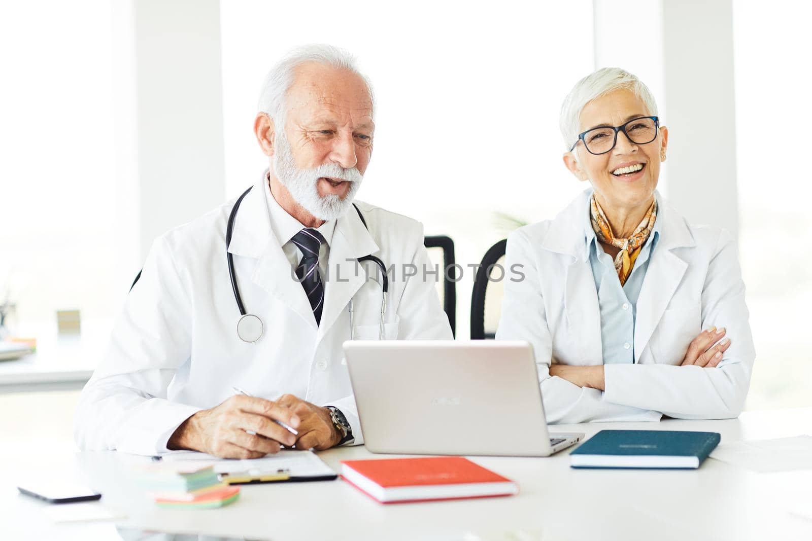 portrait of a senior doctors with laptop sitting on their office