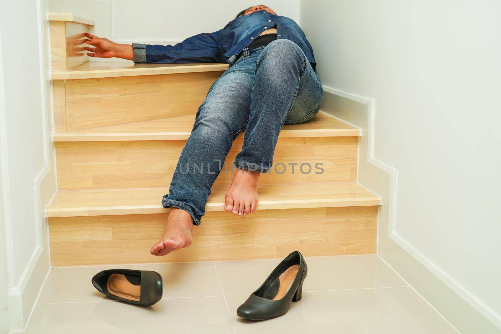 Asian business woman pain ankle, foot with leg cramp and fall down the stairs because slippery surfaces in office.