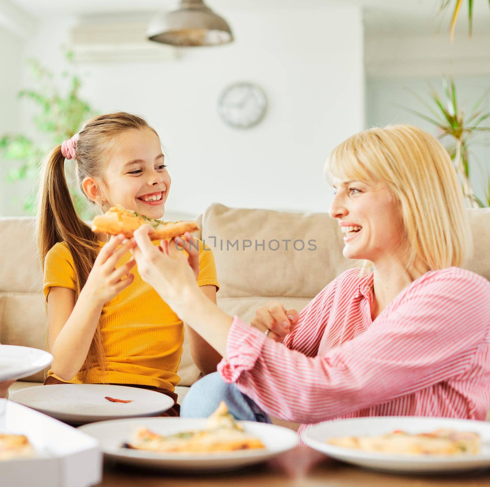 Family having meal, lunch or dinner, eating pizza and having fun at home