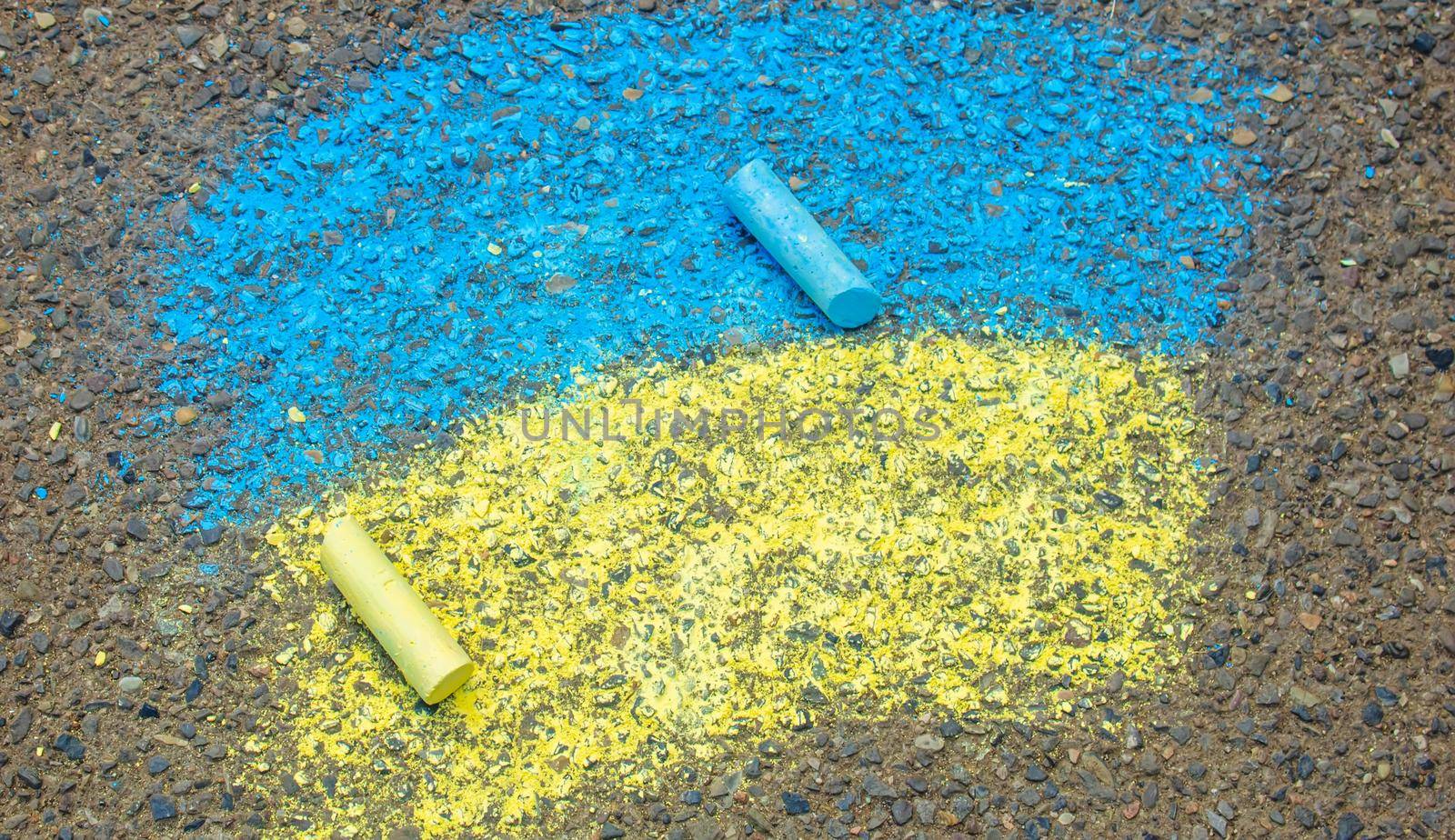 Children draw the Ukrainian flag house on the pavement. Selective focus. by mila1784