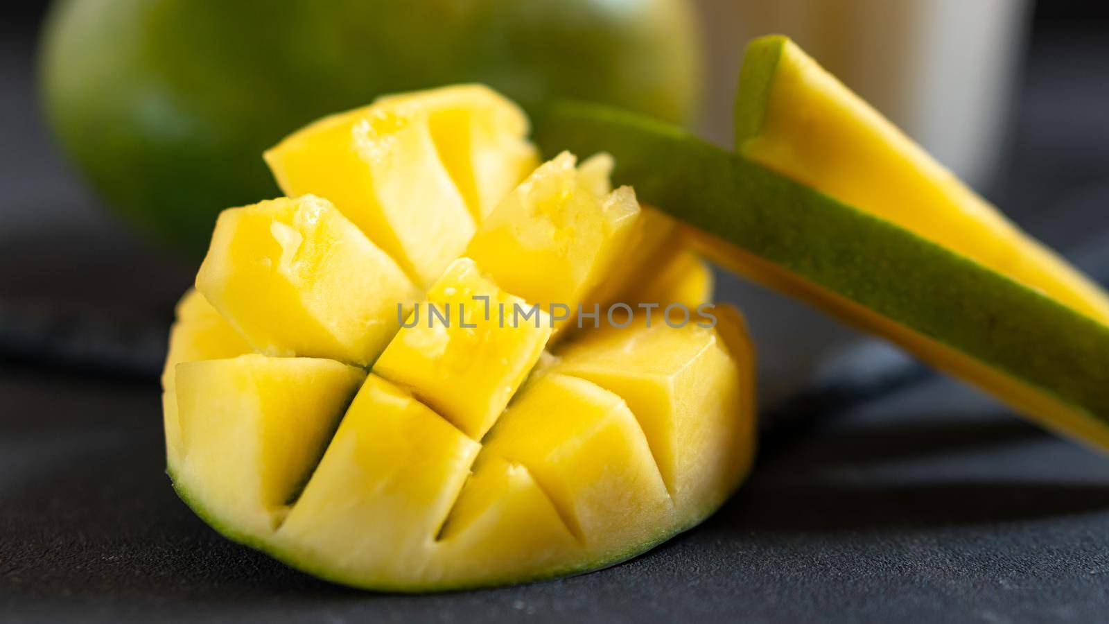 Mango cut on a dark background. Mango in home conditions not neatly cut.