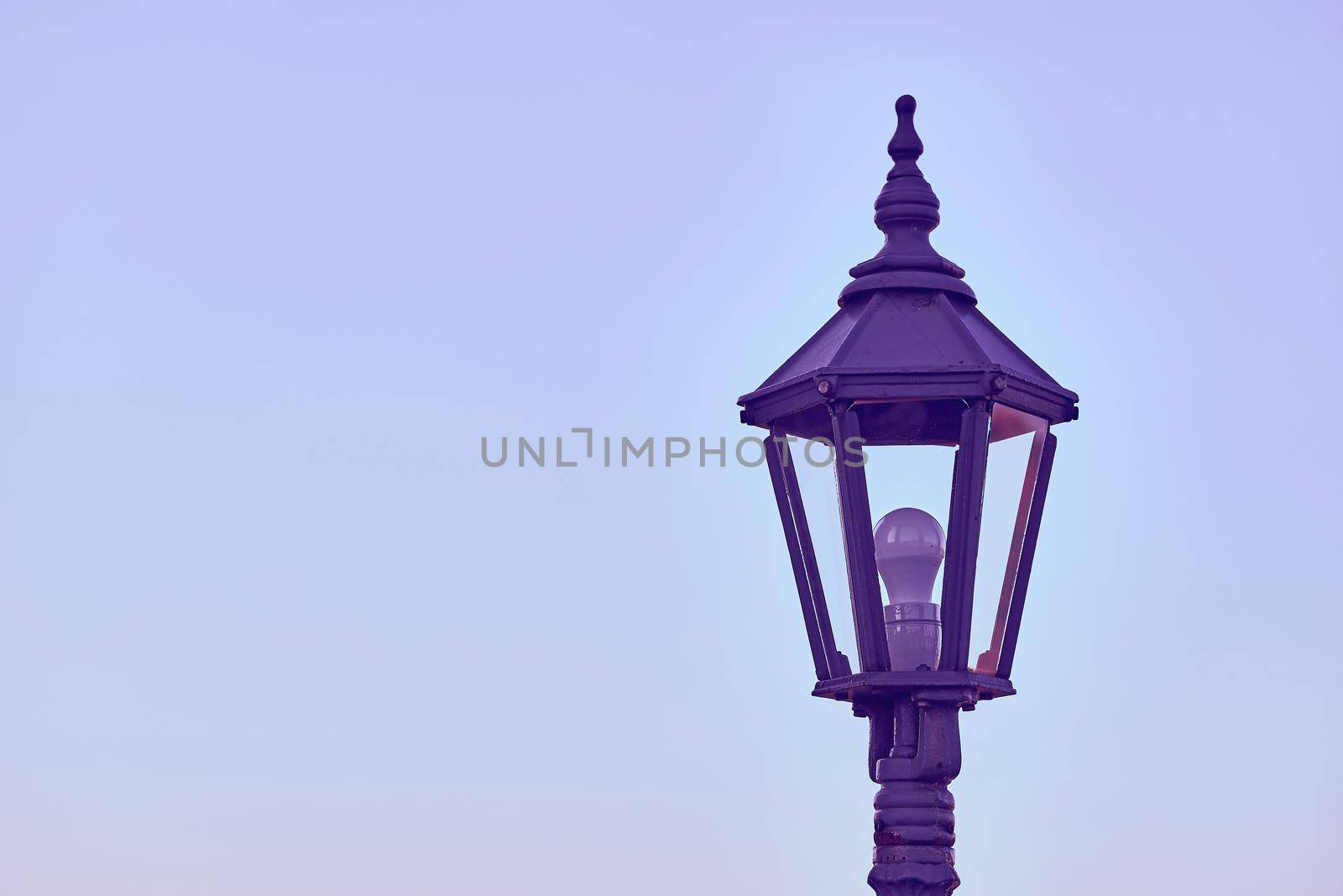 Lonely purple lantern with LED bulb and evening blue calm sky by jovani68