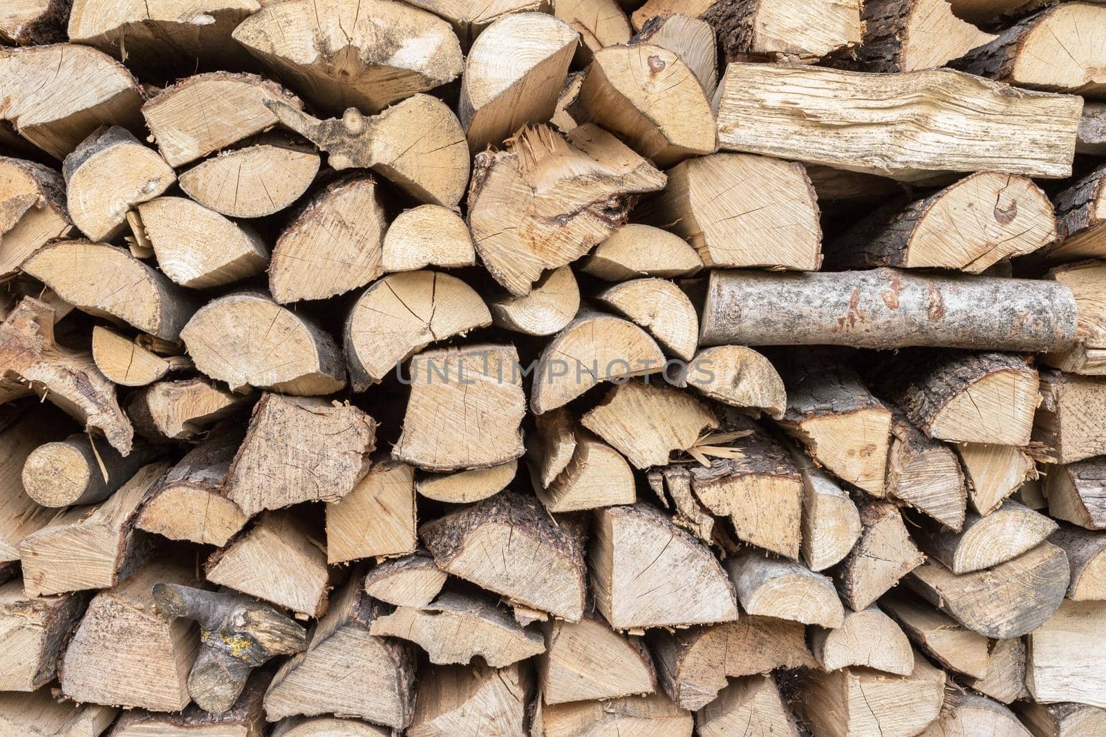 Full Frame Pile of Firewood Background Weathered Cracked Wood Texture.