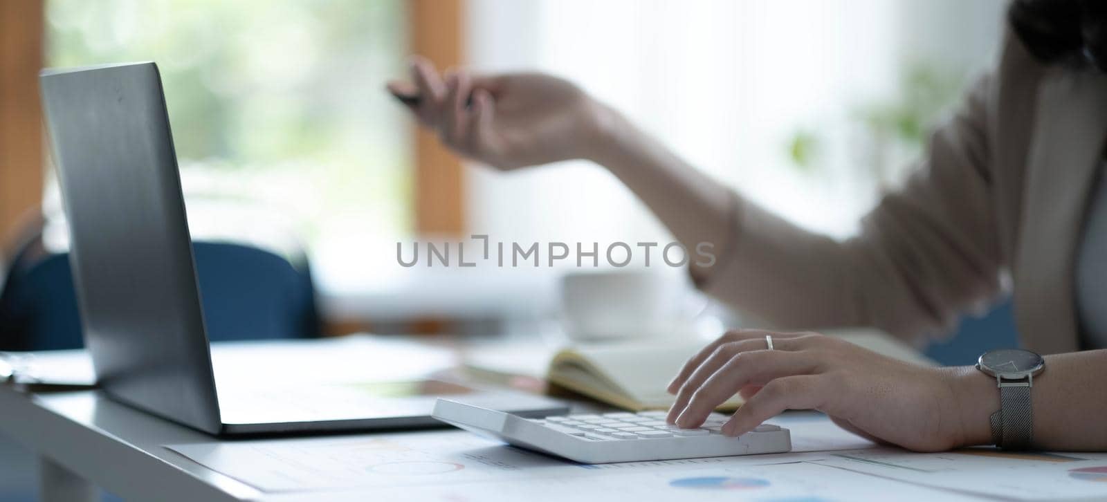 Close up Business woman hand using calculator to calculate the company's financial results and budget. Account Audit Concept..