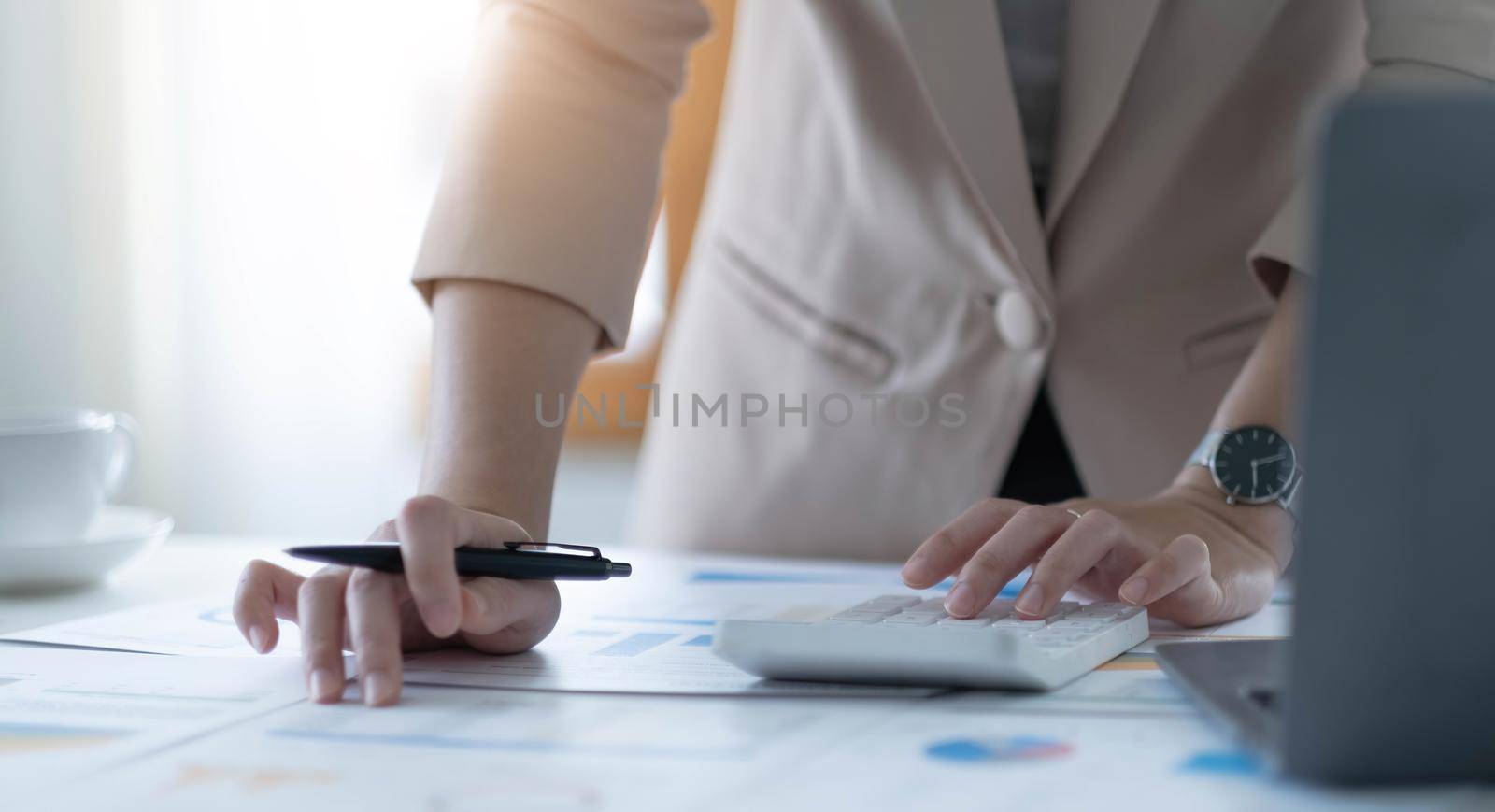 Close up business woman using calculator for do math finance in office and business working background, tax, accounting, statistics and analytic research concept by wichayada