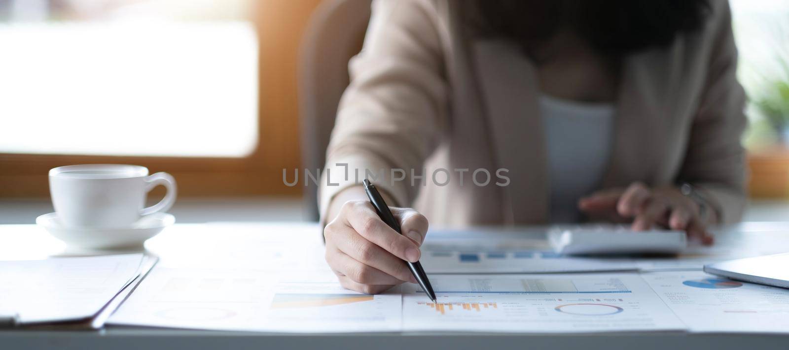 Close up of Business woman investment consultant analysis company annual financial report balance sheet statement working with documents graphs. Concept picture of economy, marketing by wichayada