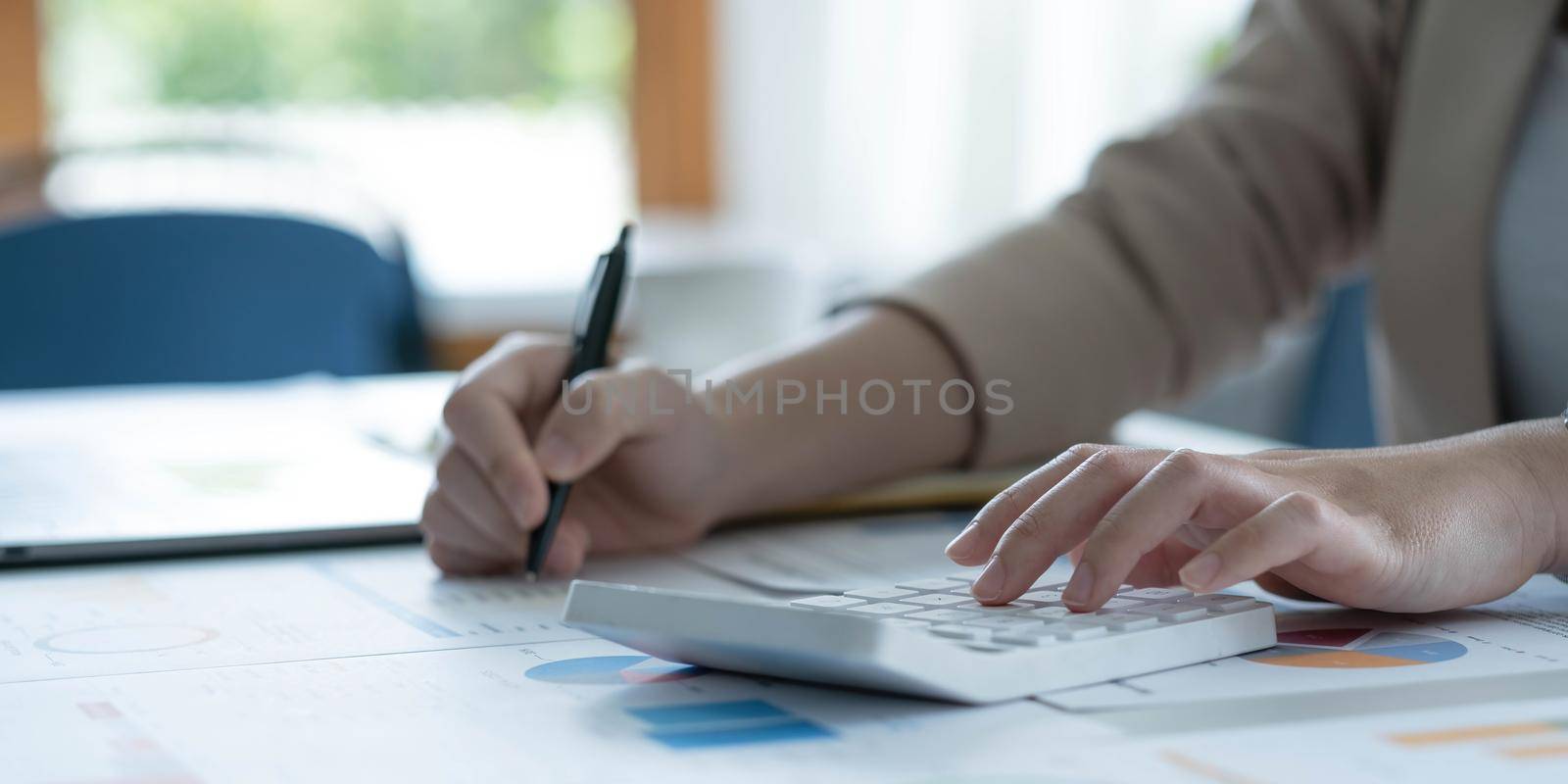Businesswoman accountant working audit and calculating expense financial data on graph documents, doing finance in workplace. by wichayada