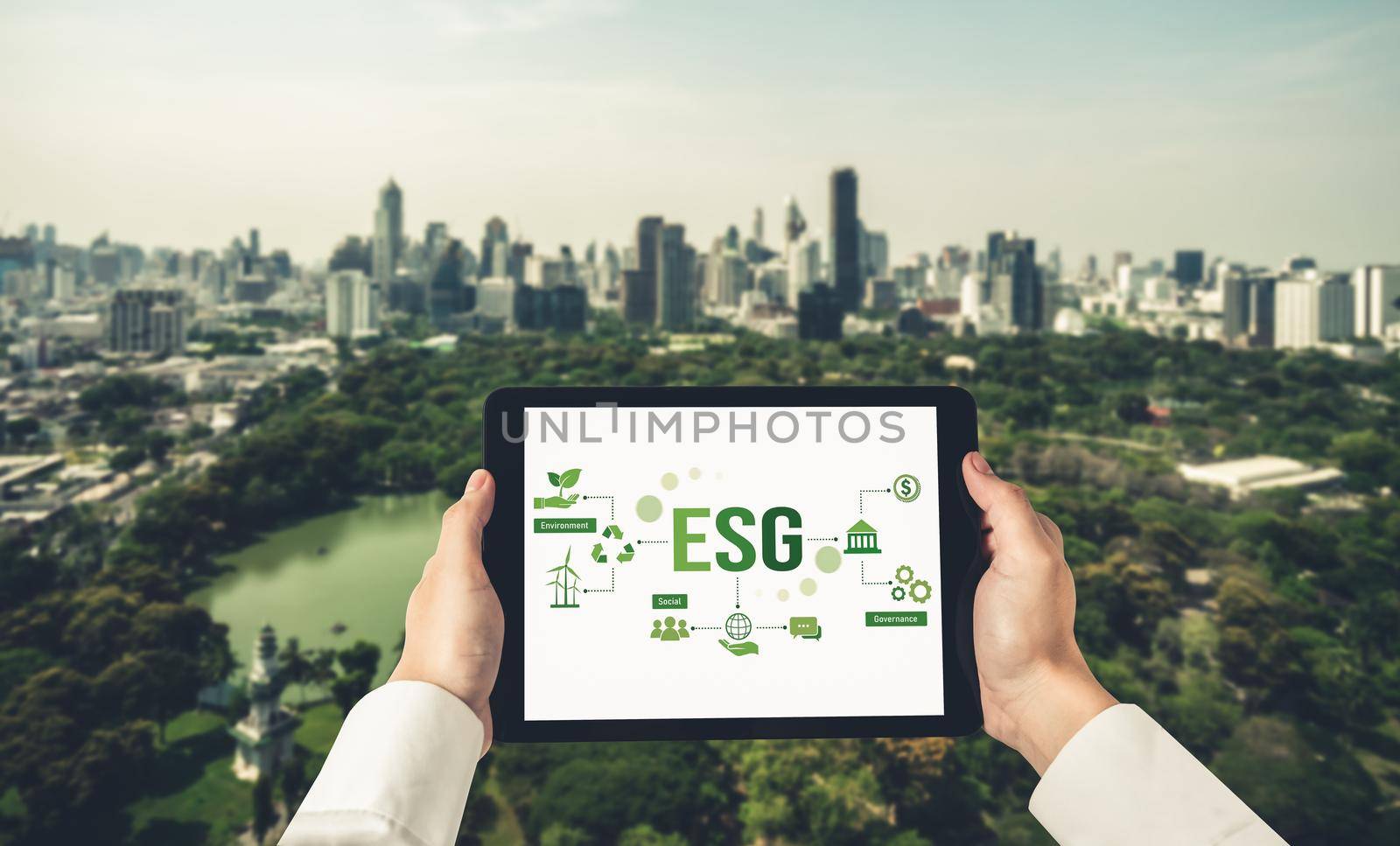 Green business transformation for environment saving and ESG business concept. Businessman using tablet to set corporate goal toward environmental friendly management and alternative clean energy use.