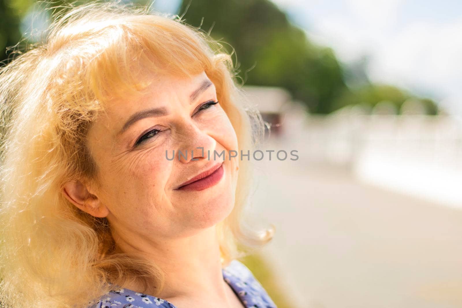 adult woman with wrinkles on her face smiling broadly. middle aged blonde laughing. High quality photo