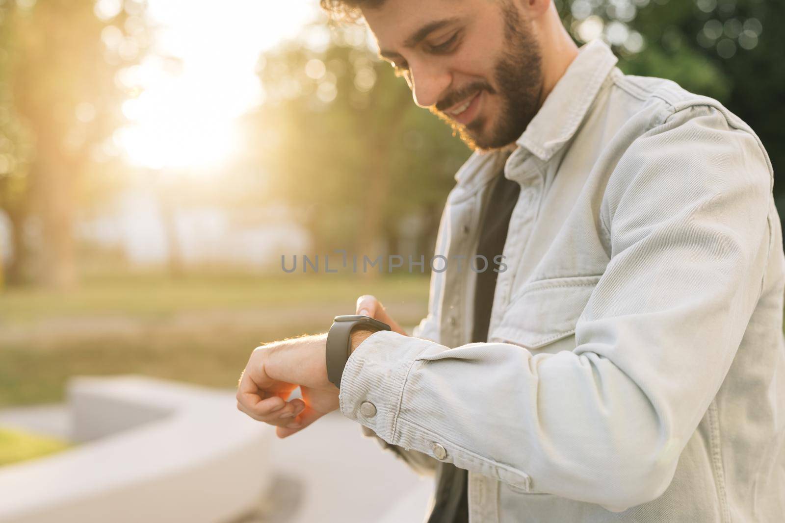 Smartwatch. Smartwatch on a man's hand outdoor. Man's hand touching a smart watch. Closeup shot of male's hand uses of wearable smart watch at outdoor.